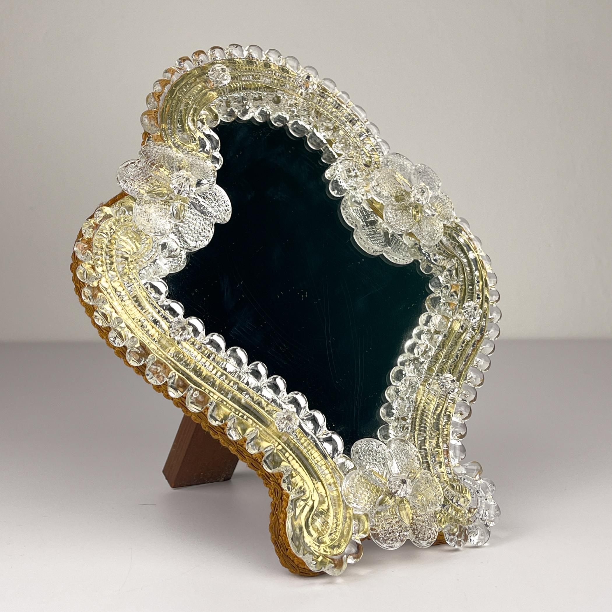 Charmanter Spiegel aus Murano-Glas, hergestellt in Venedig (Italien) in den 1950er Jahren. Der Spiegel kann als Tisch- oder Wandspiegel verwendet werden.
Der Spiegel ist in einem sehr guten, alten Zustand.

Abmessungen:
Breite: 23 cm / 9 Zoll
Höhe: