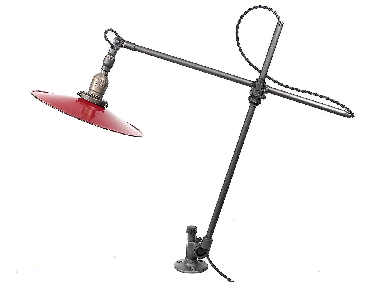 This is n original O. C. White articulated arm lamp. It has a 3 hole mounting bracket and can be used to directly to a work bench or wall. It has a beautiful 10 inch flat red over white porcelain shade. This shade and arm make the perfect