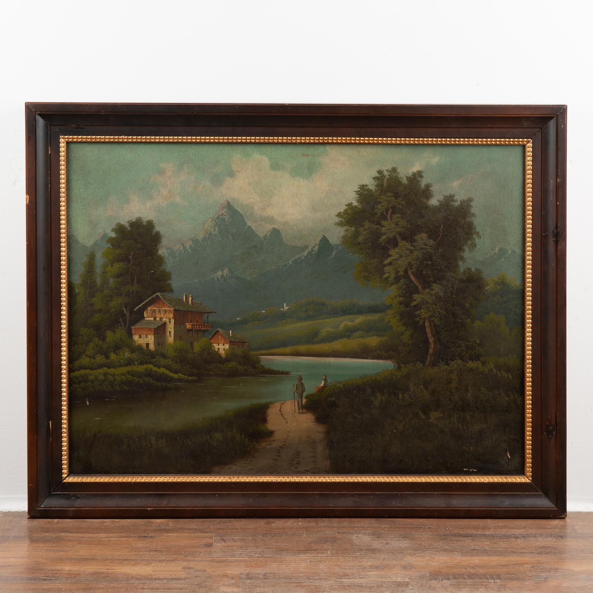 Original oil on canvas painting of peaceful European country scene along river with mountains in background, couple in foreground. Artist unknown.
Old repairs/re-touches. Craquelure, some pin pricks, visible scuffs, etc. Canvas is intact and will