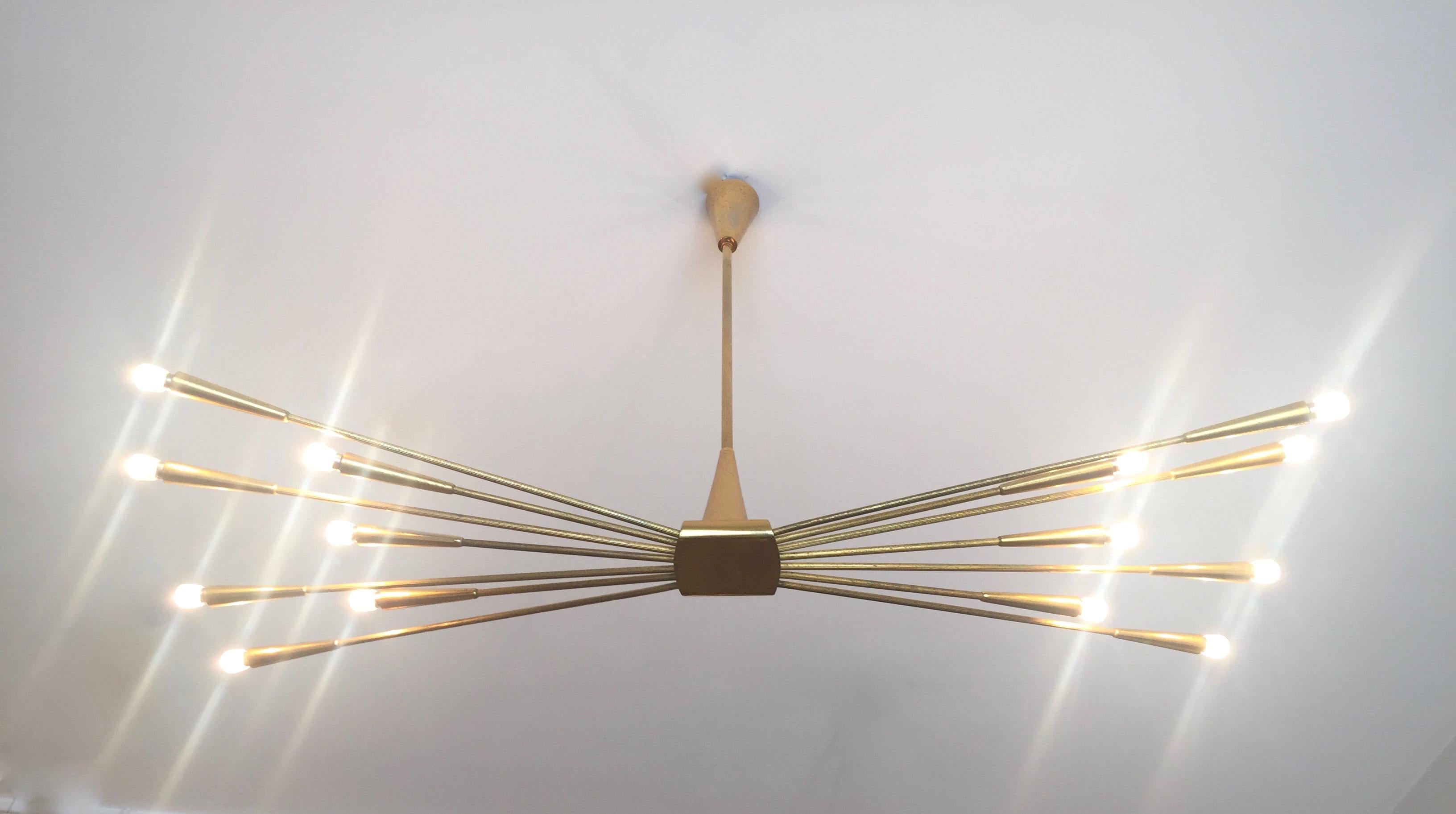 An superb original mirrored -polished brass chandelier designed by Oscar Torlasco and edited in the 50s. Brass frame and fourteen striated arms. Original label. Adjustable in height and rewired for USA use.