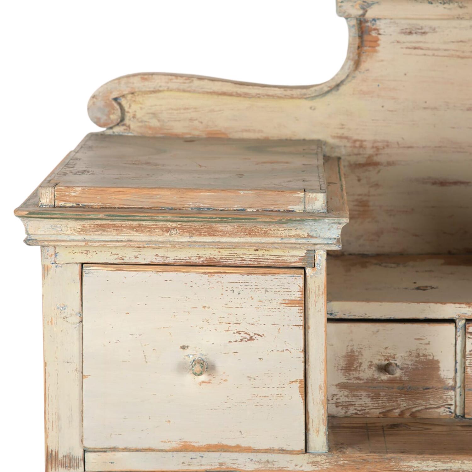 This 19th century Swedish buffet features original paint, with a decorative carved freeze. Two larger doors open to further storage below four storage drawers.