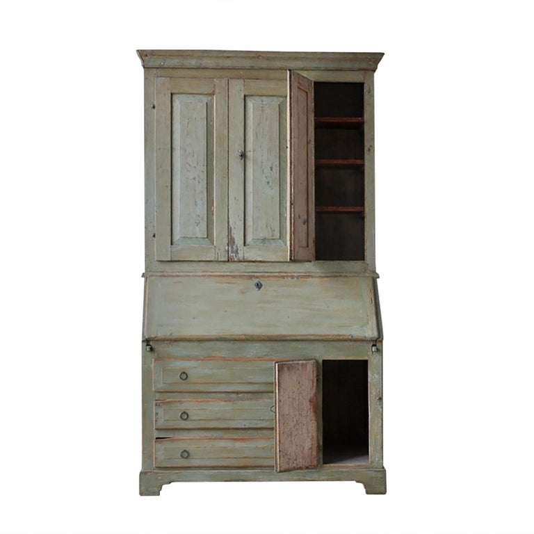 An unusual Swedish Secretary from Jamtland with a three door design on the top section. A folding front desk opens to drawers and storage space, beneath this are three drawers, and a further side cupboard.