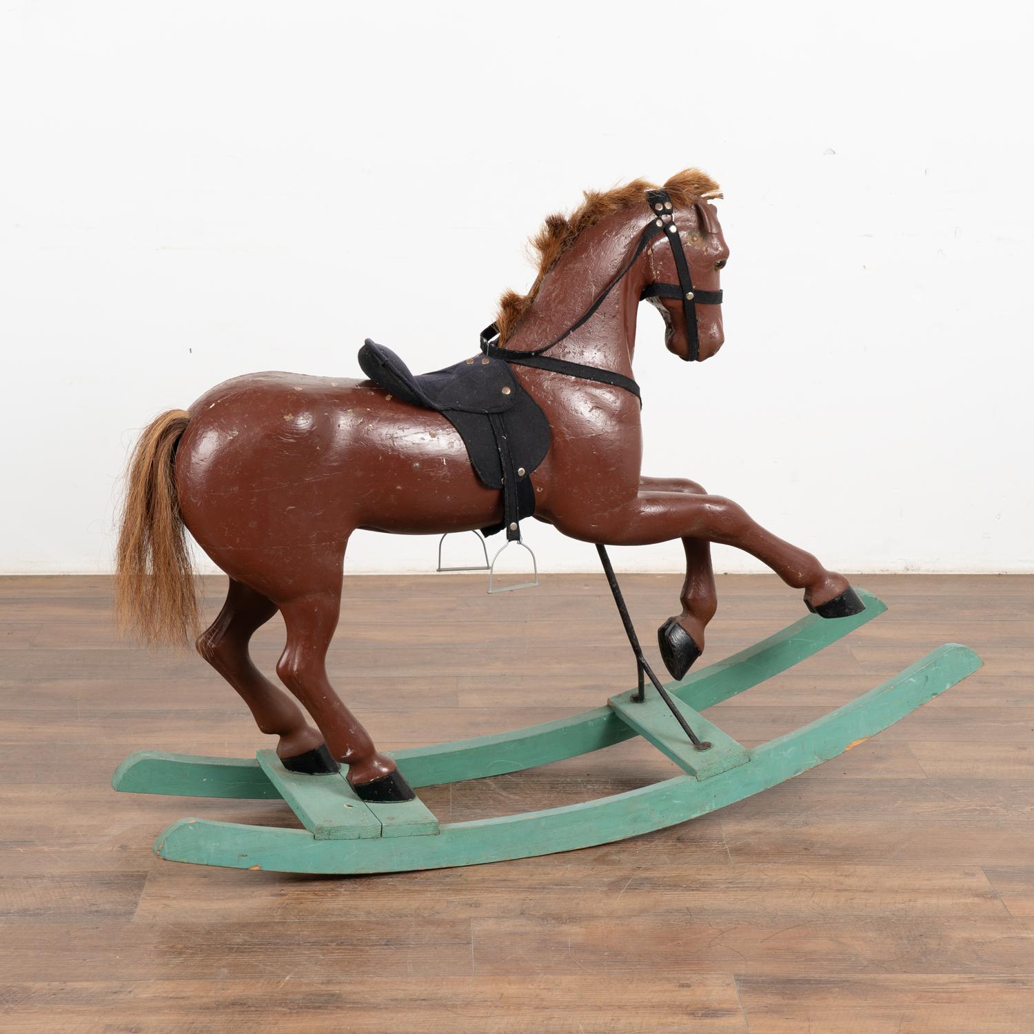 It is the worn look that creates the wonderful appeal of this original painted and carved rocking horse from Sweden.
The brown/brick red paint has been distressed through years of use; see cracks, chips, dings some wear down to natural pine below.