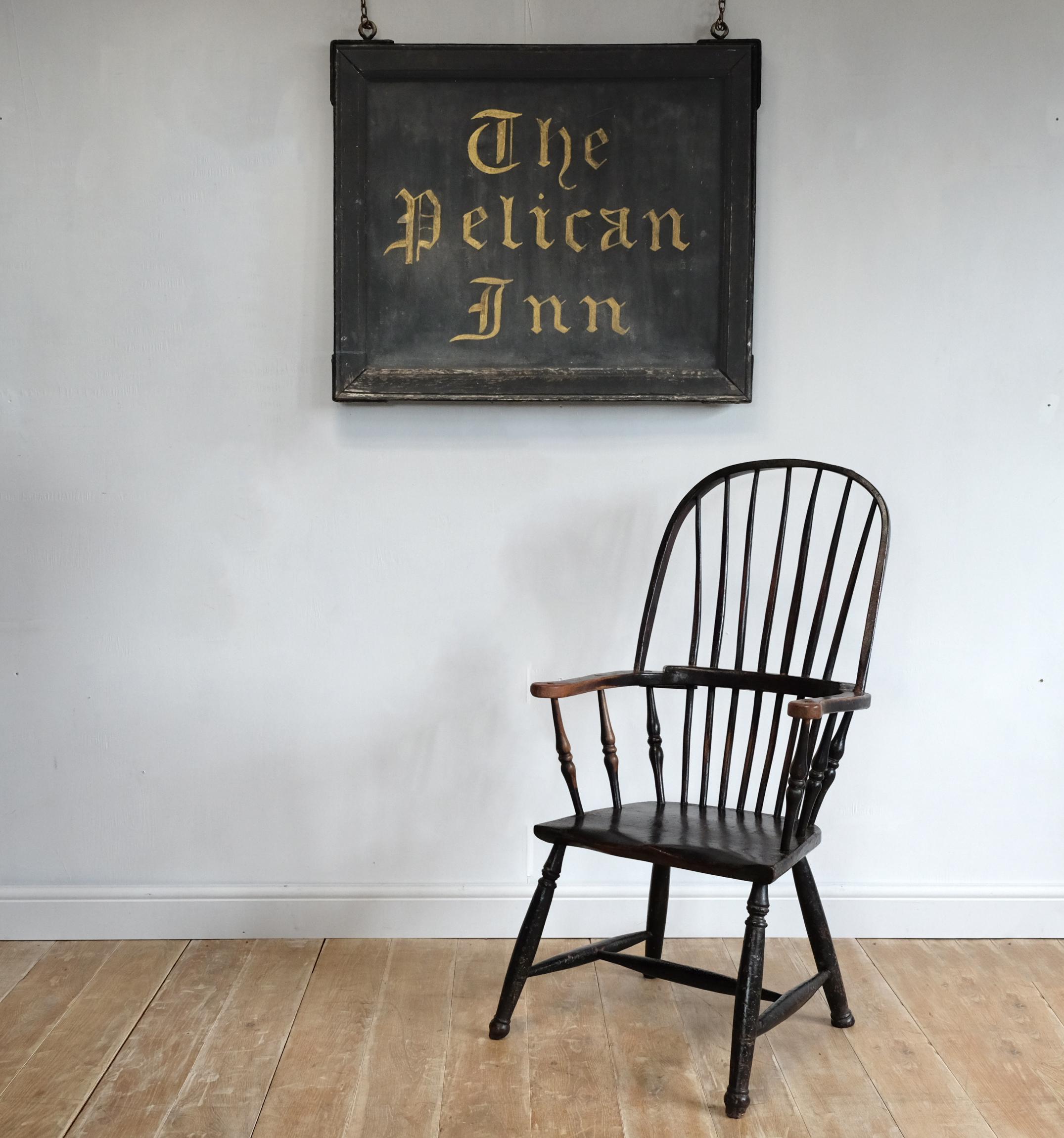 A large original hand painted sign for the Pelican Inn, believed to be from the Pelican Inn in Stapleford near Salisbury, England. Gilt lettering on black background in heavy painted timber frame, with original hanging loops. Charming faded