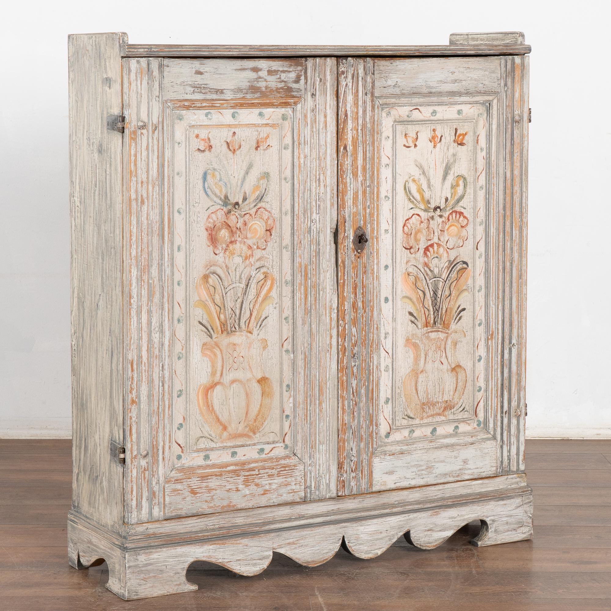 Original painted narrow cabinet from the Swedish countryside. The lovely soft colors of the decorative floral panels are displayed well against the distressed gray painted finish, revealing the warm natural pine patina below that is a result of