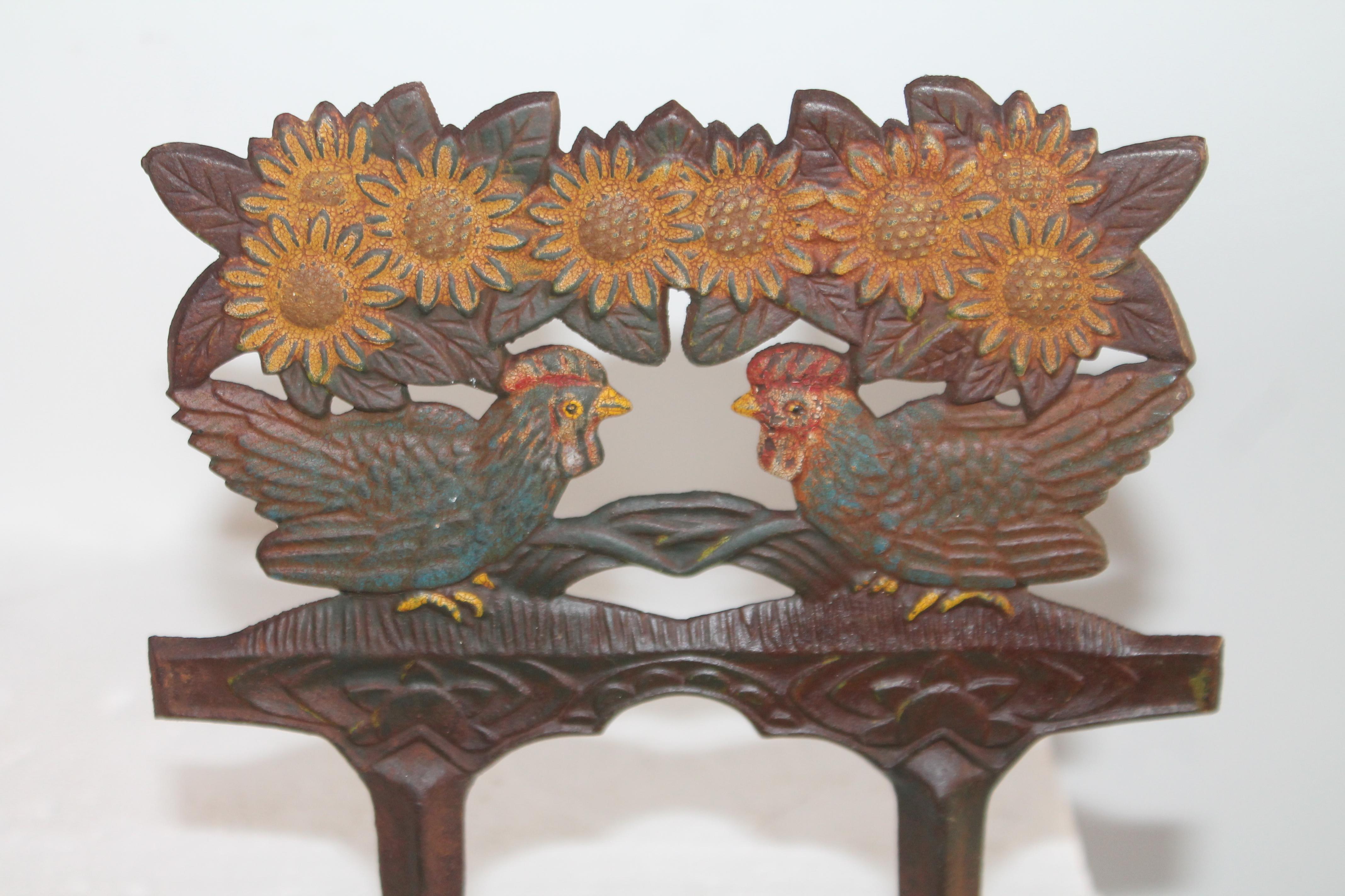 Original painted iron garden ornament with roosters and daisy's in good condition.