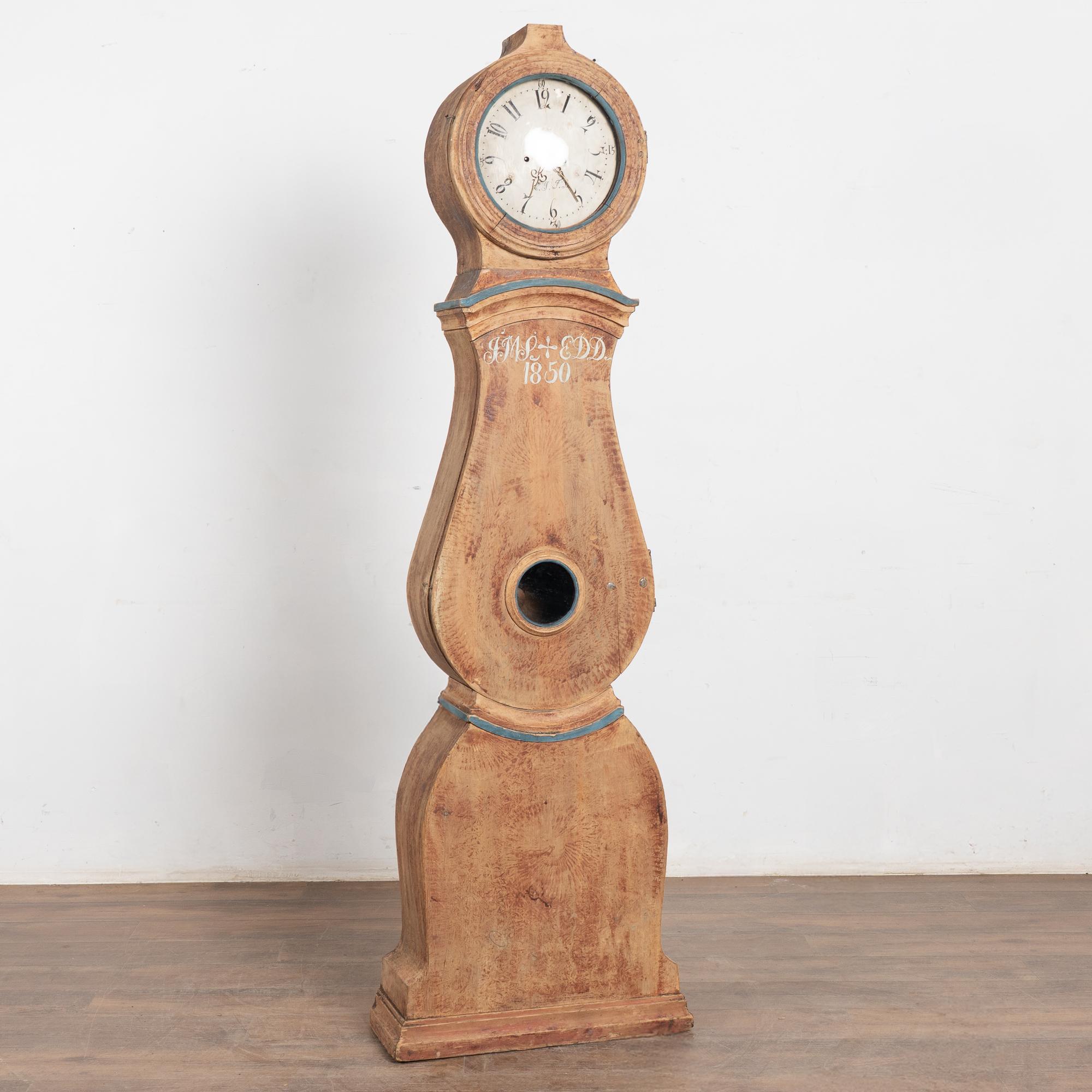 Swedish Mora grandfather clock dated 1850, crafted in pine with original brick-red or burgundy paint now softly scraped to reveal the natural wood beneath. A hand-painted monogram and date accent the front (appears to be newer paint on top of