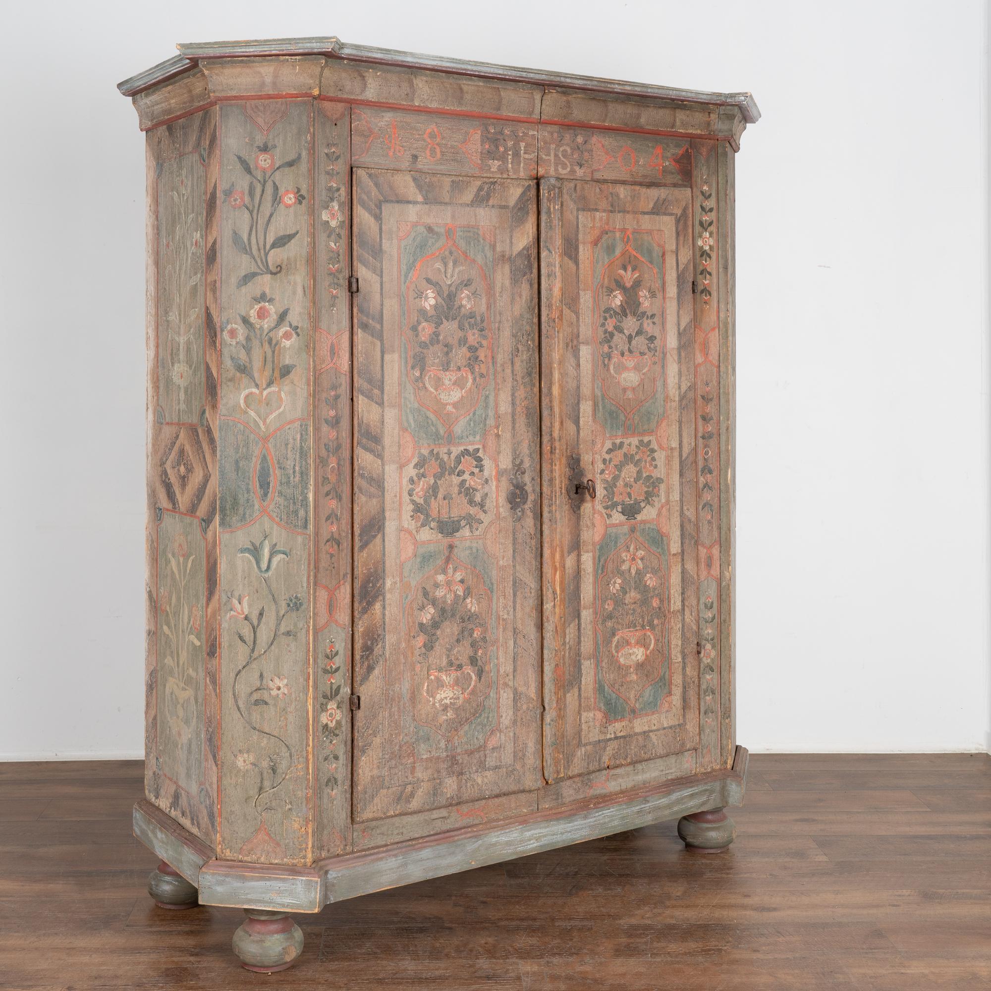 This lovely painted armoire still maintains the quality and details of the original hand-painted finish. The soft, gentle colors with delightful floral motifs are beautifully executed.
Notice the panels of flowers against the pale green and brown