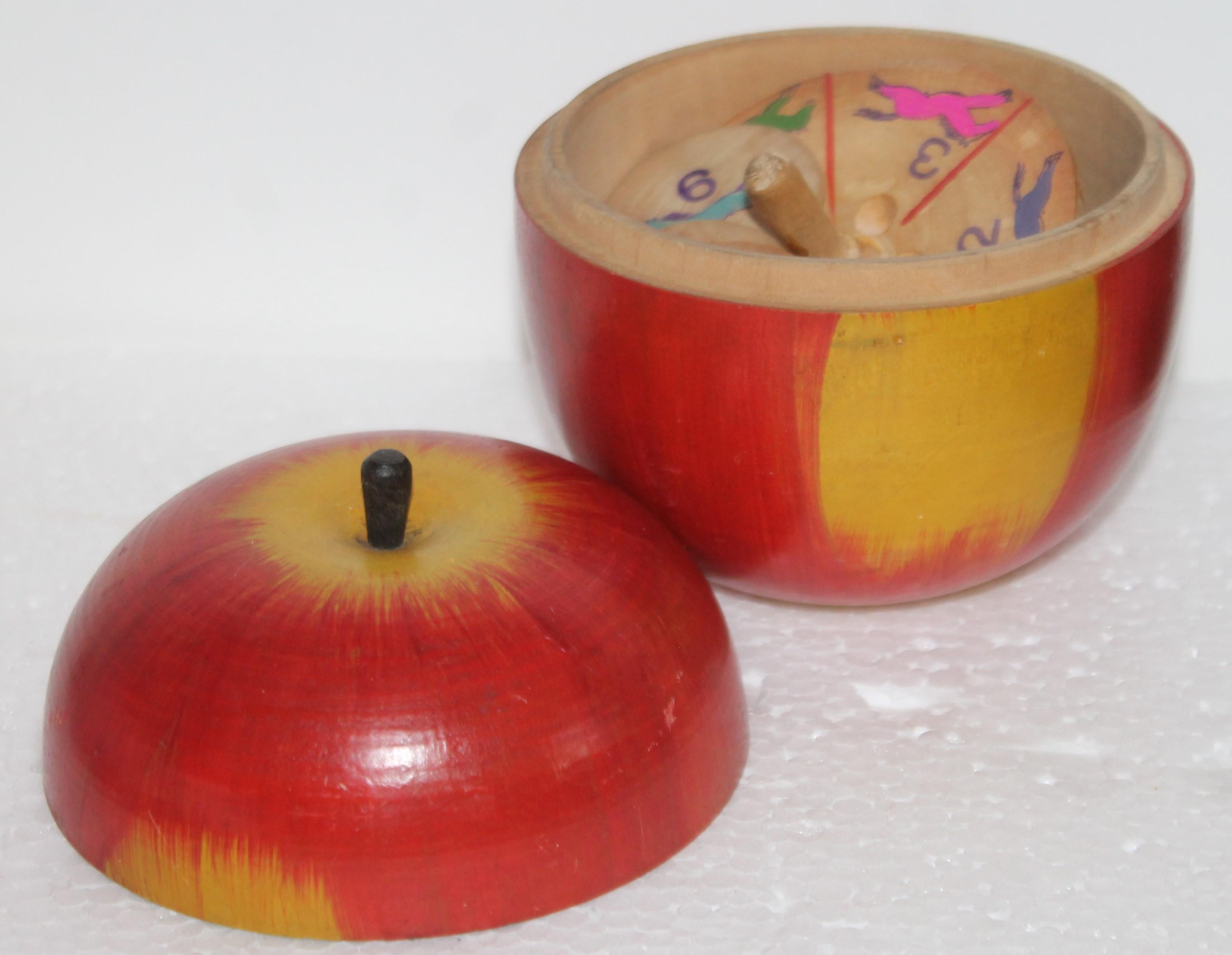 This fun polychrome painted apple in original surface paint. Inside is a wooded spinner top game. So cool this wooden painted apple.