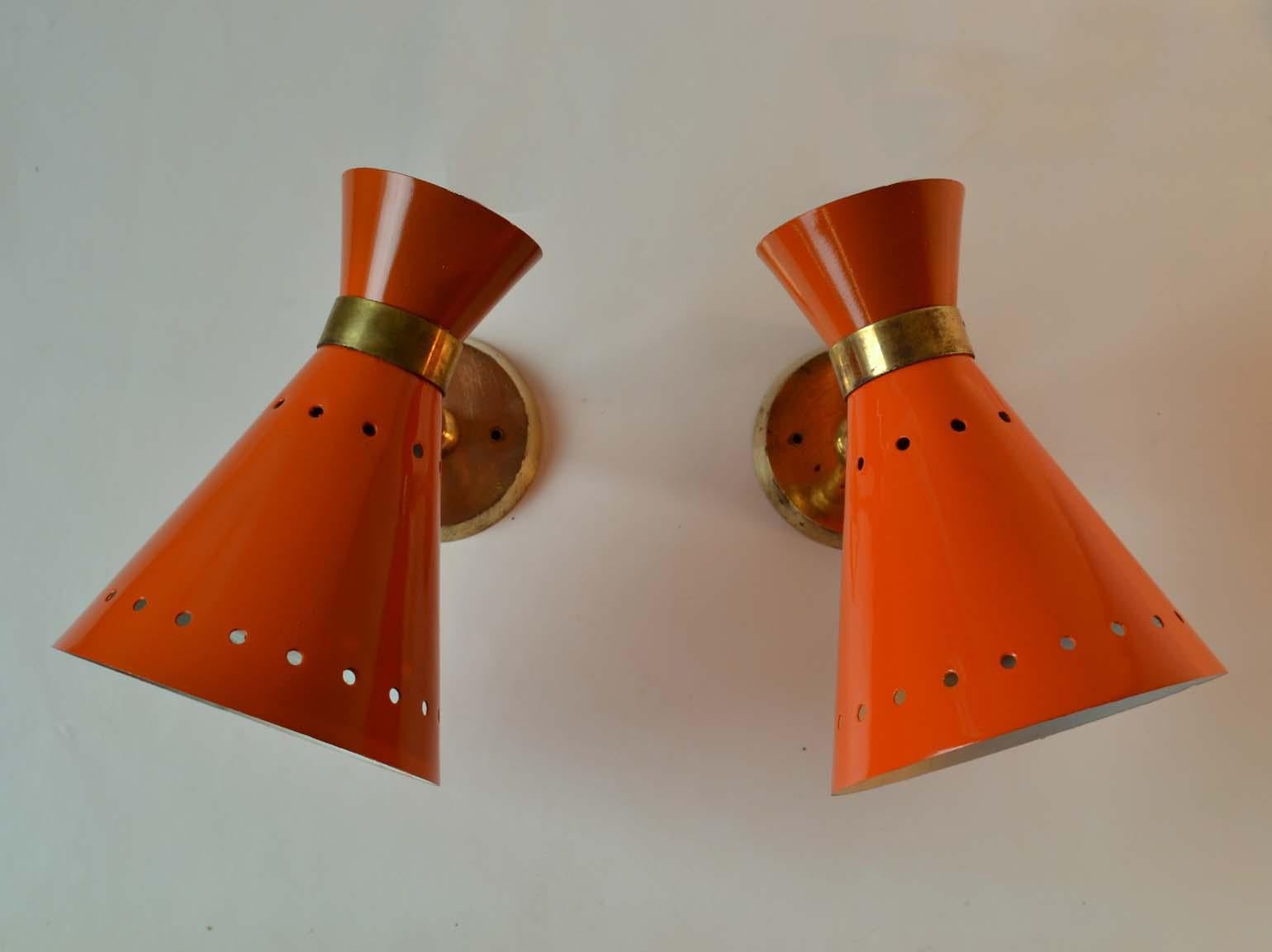 Pair of original Mid-Century Modern Italian orange enameled aluminum and brass hourglass shape sconces with adjustable joints to angle the light source. These Italian enameled sconces attributed to Stilnovo were produced in the 1950s-1960s and are