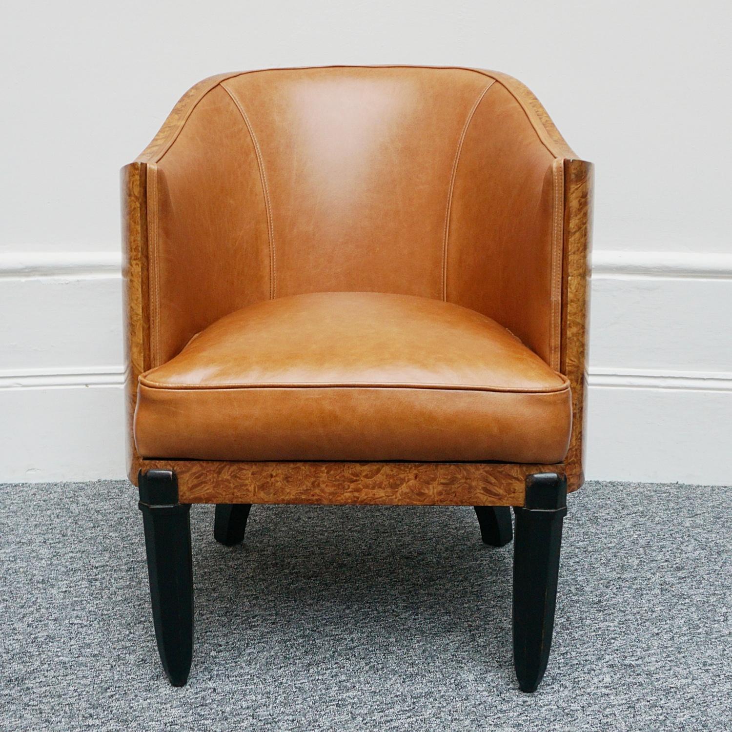 A pair of Art Deco club chairs by Maurice Adams. Burr walnut wraparound veneer with ebonized tapered legs. Re-upholstered in brown leather. 

Dimensions: H 76.5cm W 60cm D 68cm Seat H 48cm.

Origin: English

Date: circa 1935

The self