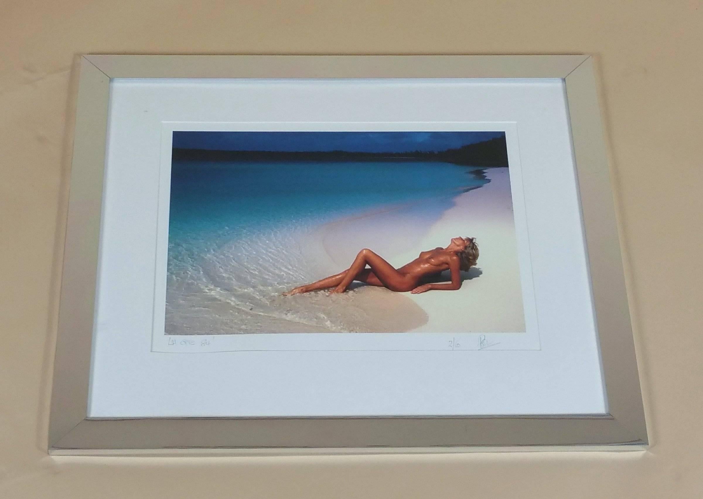 One of two original photographs signed and dated by the artist, which is signed ‘Poole’, dated 1984. The color photograph depicts a nude woman reclining on the sand of a beach, possibly on the west coast of the United States. The picture measures 26