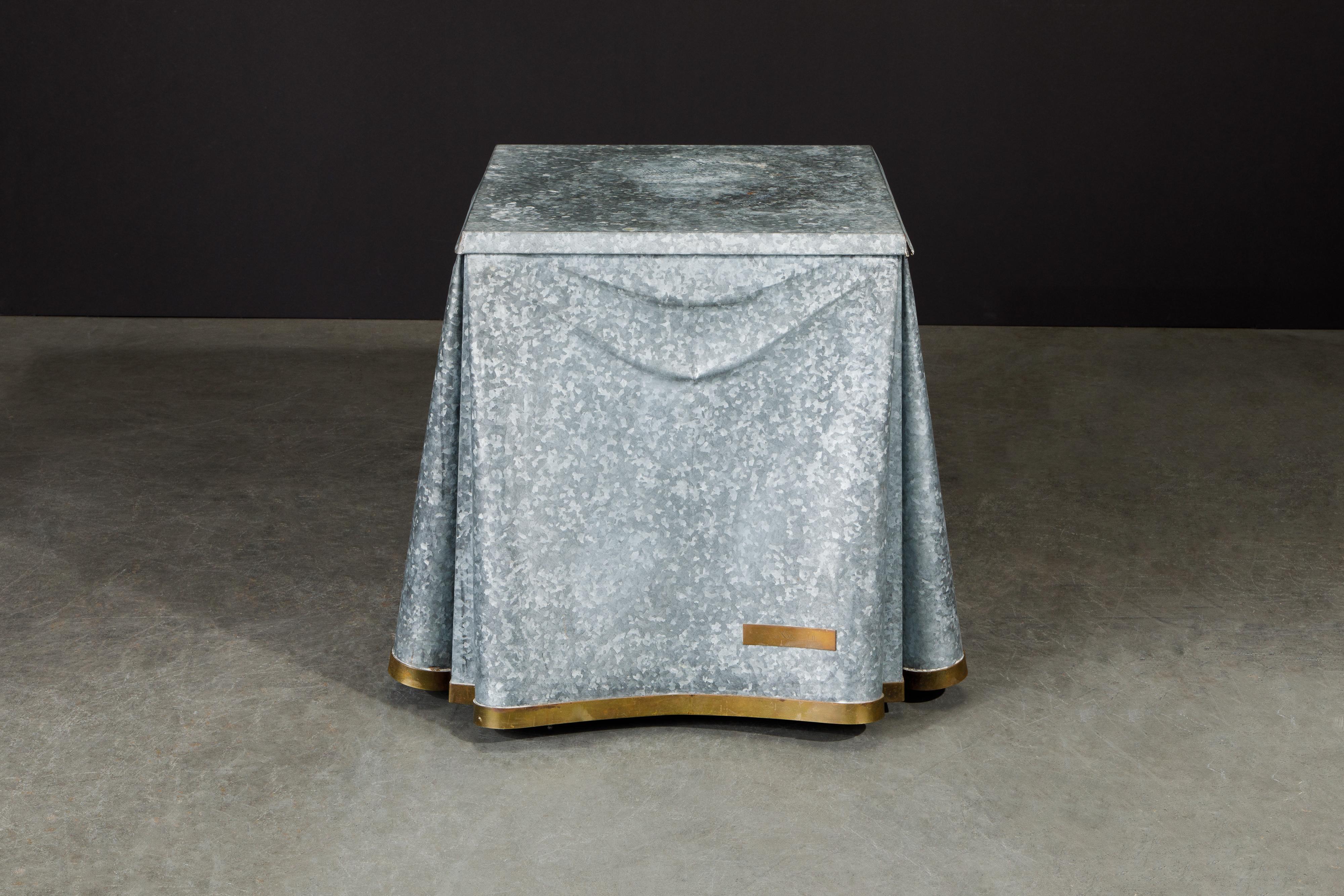 This exceptionally rare and high-sought after collectors item is the John Dickinson model #107 drape end table with trompe-l'œil fabric motif in galvanized steel and brass binding. This piece of functional fine art is suited for a design collector,