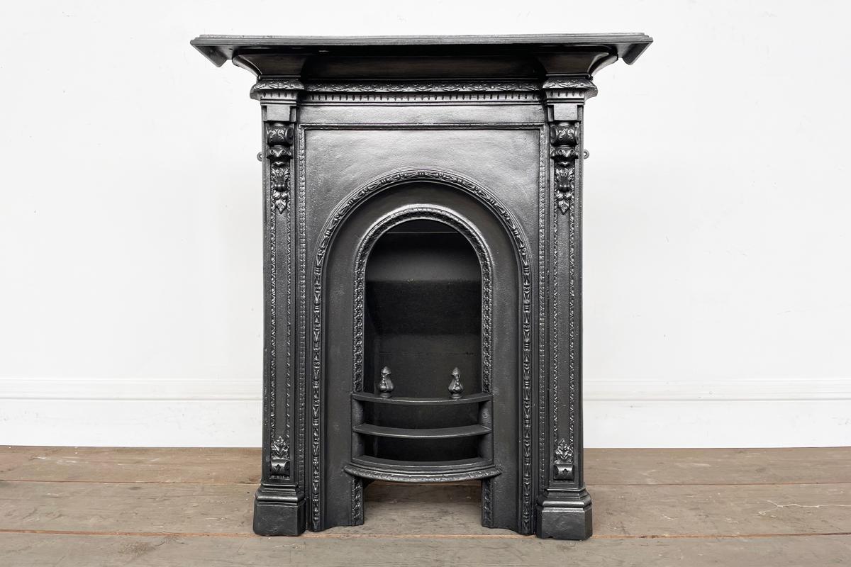 Reclaimed ornate mid Victorian cast iron bedroom fireplace with an arched aperture. Circa 1870

This grate has been finished with traditional black grate polish, leaving a gun metal / pewter shine and complete with a new clay fireback and cast