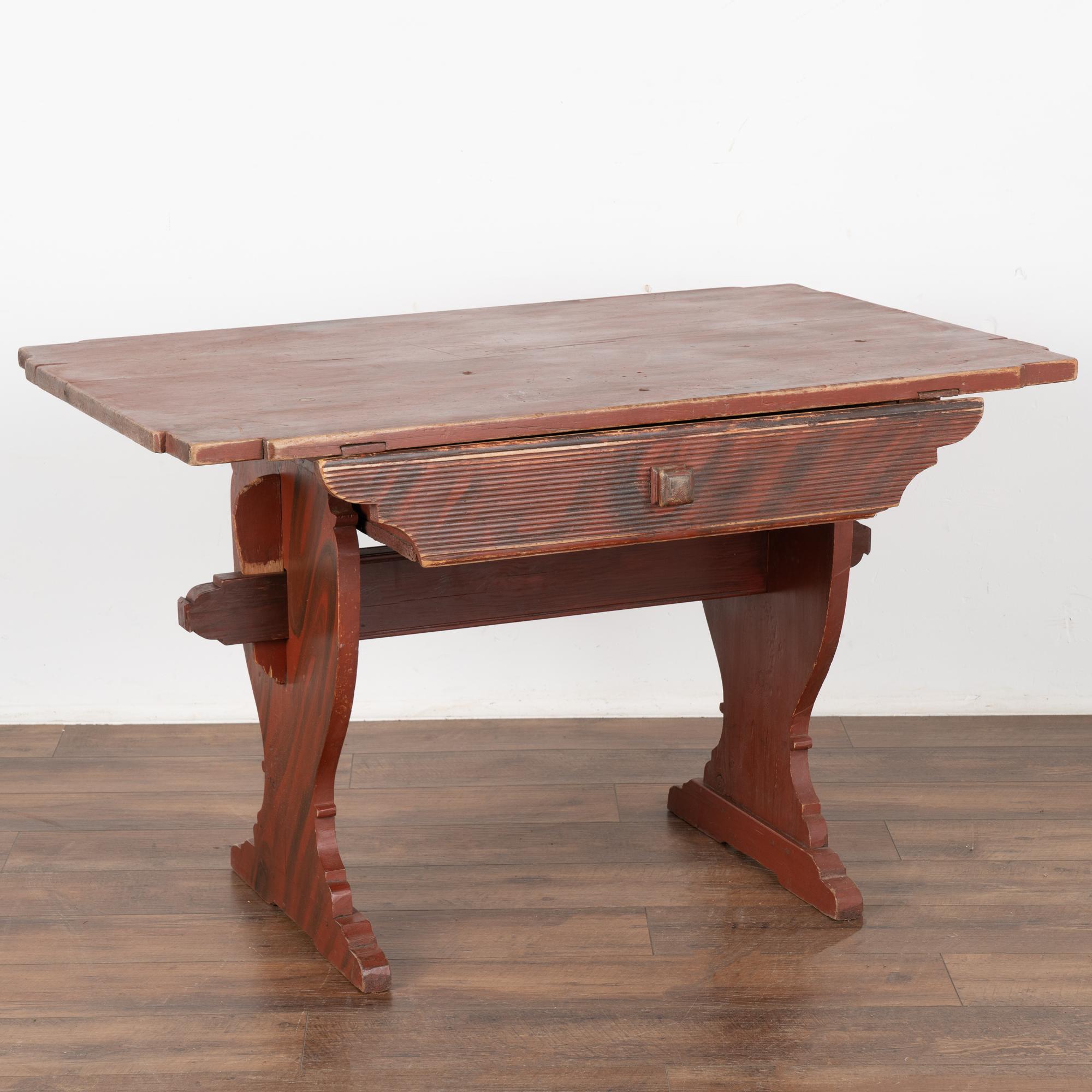 This delightful pine farm table comes from the Swedish countryside. The original faux wood painted finish was the traditional style of the era (almost 200 years old).
The original folk art painted finish is a combination of brick red and black which