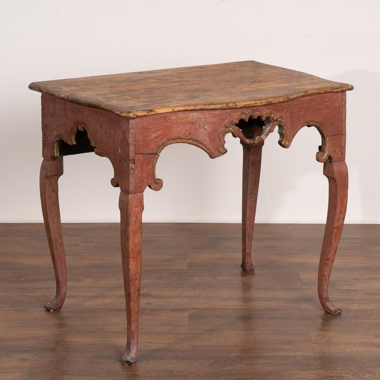 The original red painted finish has been gently distressed through generations of use, creating the wonderful worn patina found in this lovely rococo pine side table.
Note the decorative carving and slender long cabriolet legs that add a romantic