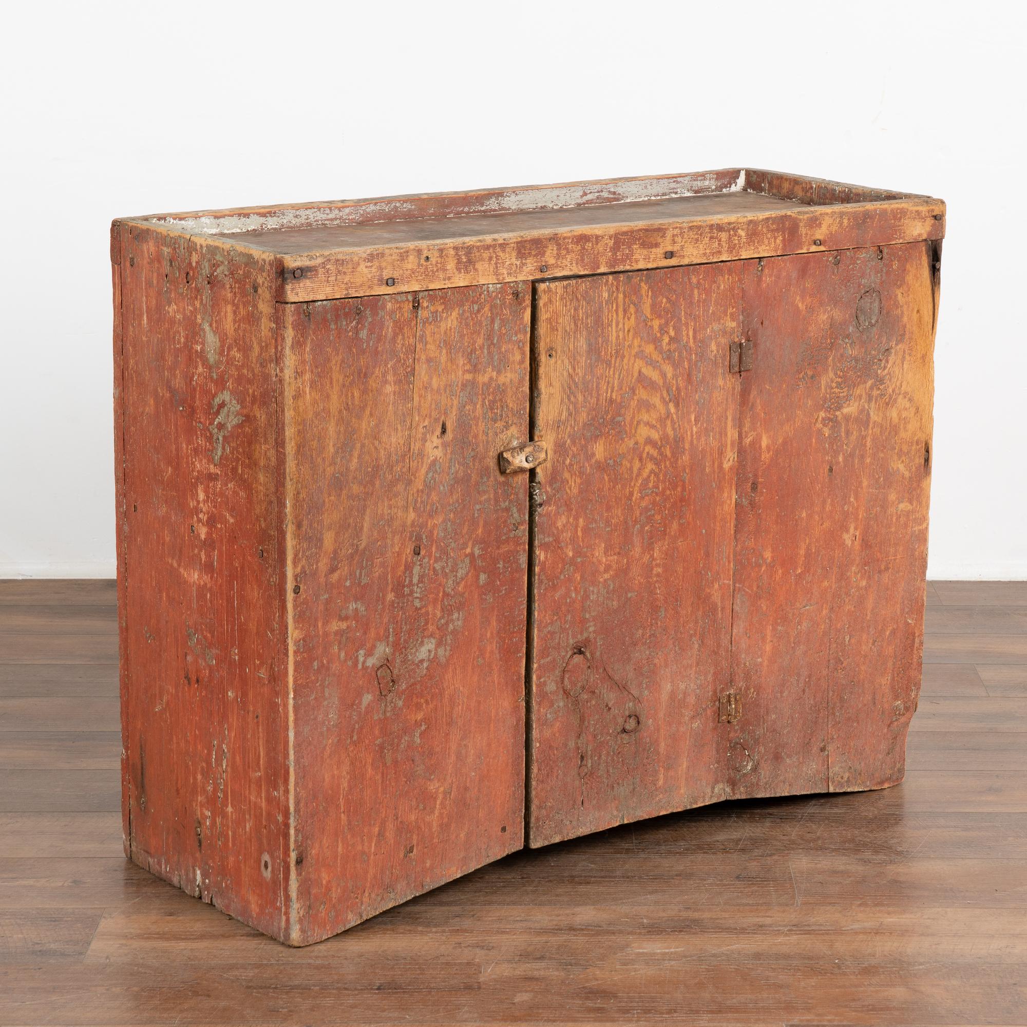 This rustic cabinet has great character thanks to the original red painted finish that was and still is a favorite color in Sweden.
Loaded with quirky charm, the base curves upward, center door closes with wooden peg, multiple cracks, distress, and