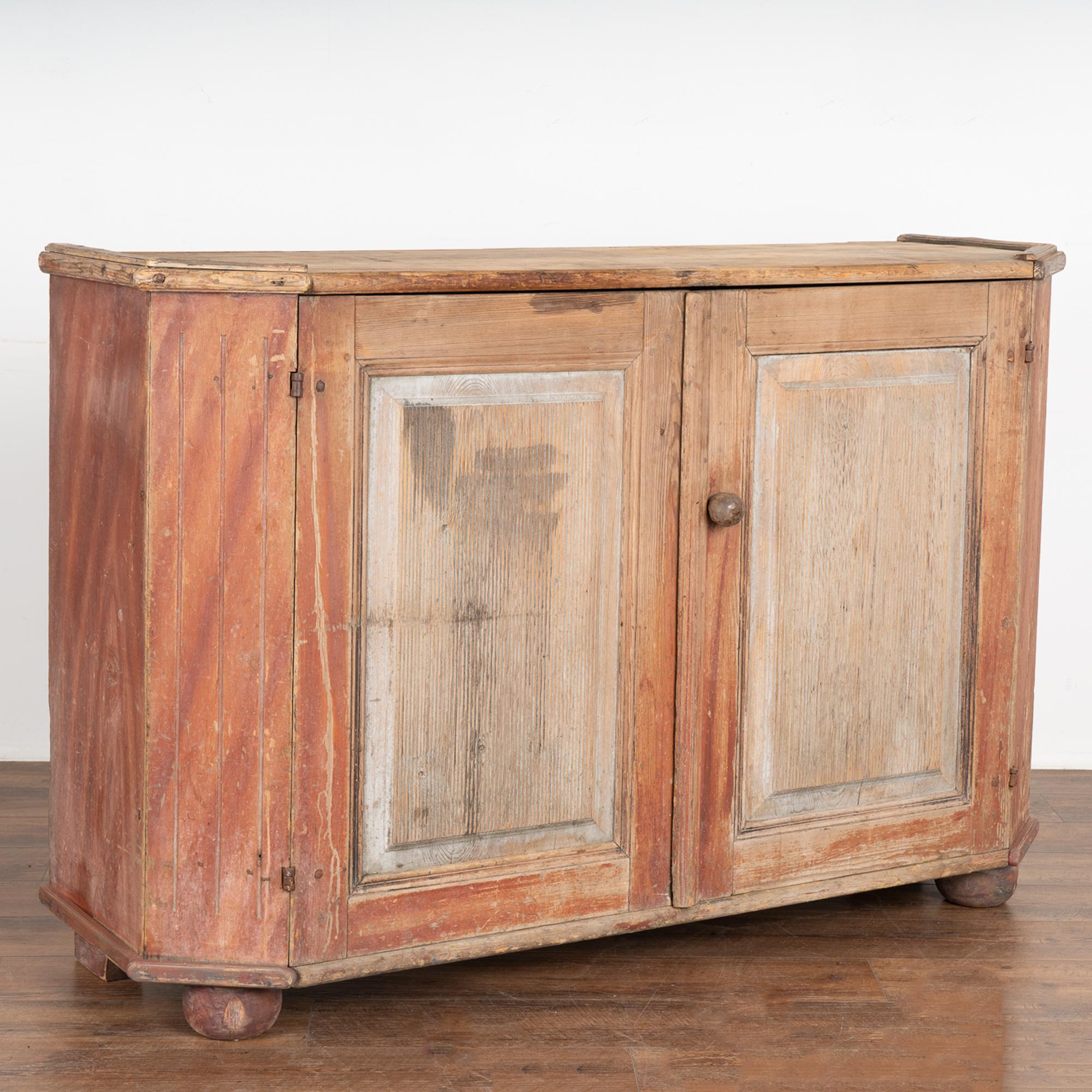 The attractive soft color pallet of this large pine Swedish sideboard comes from the original hand-painted red and white finish which has been gently scraped and softly distressed through generations of use, resulting in the warm aged patina now