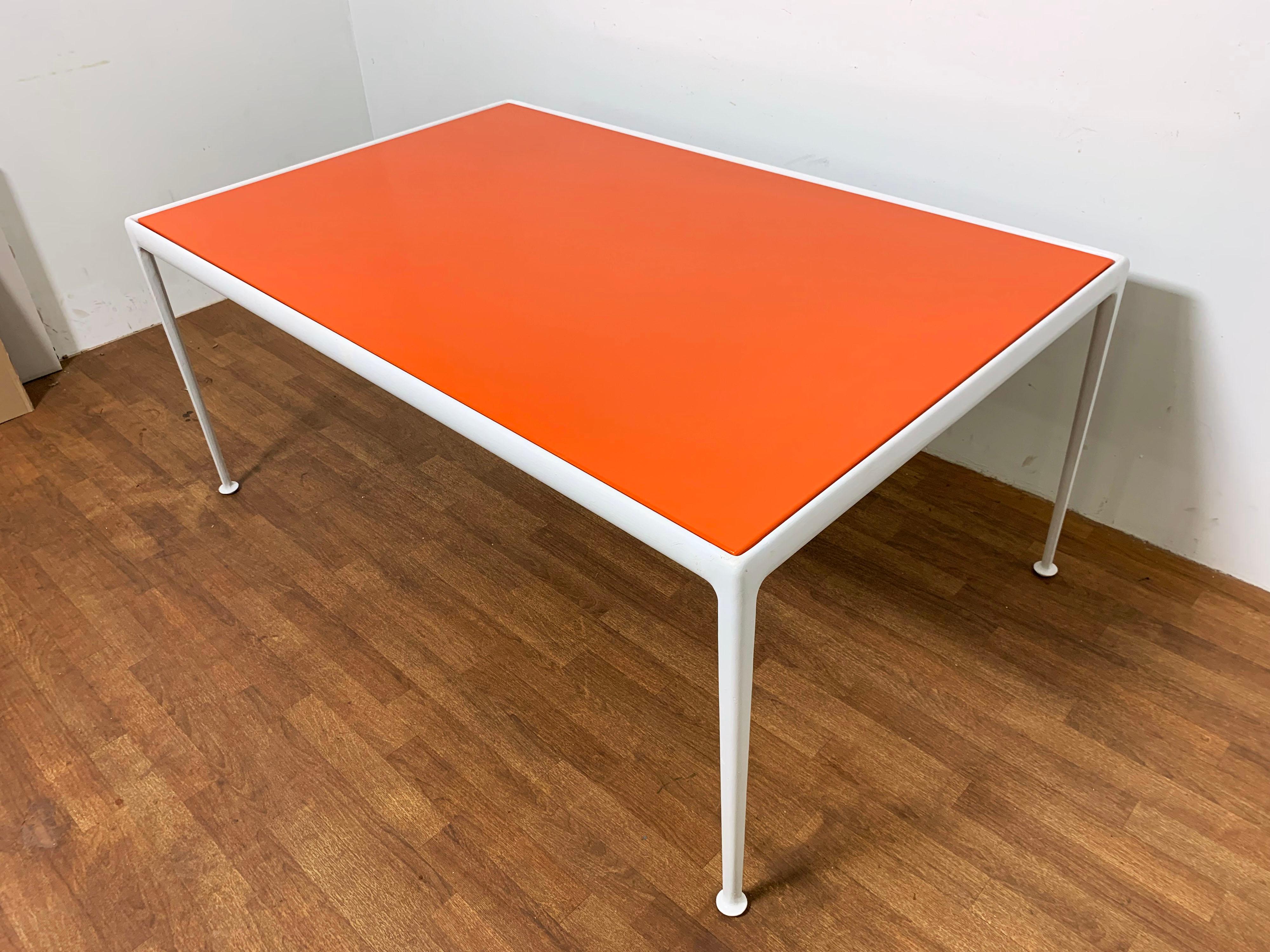 An outdoor dining table with orange enamel top from Richard Schultz’s 1966 aluminum Leisure Collection for Knoll, with four side chairs from the same series. Purchased in 1968, prior owner kept dining set in her solarium, never used outdoors.