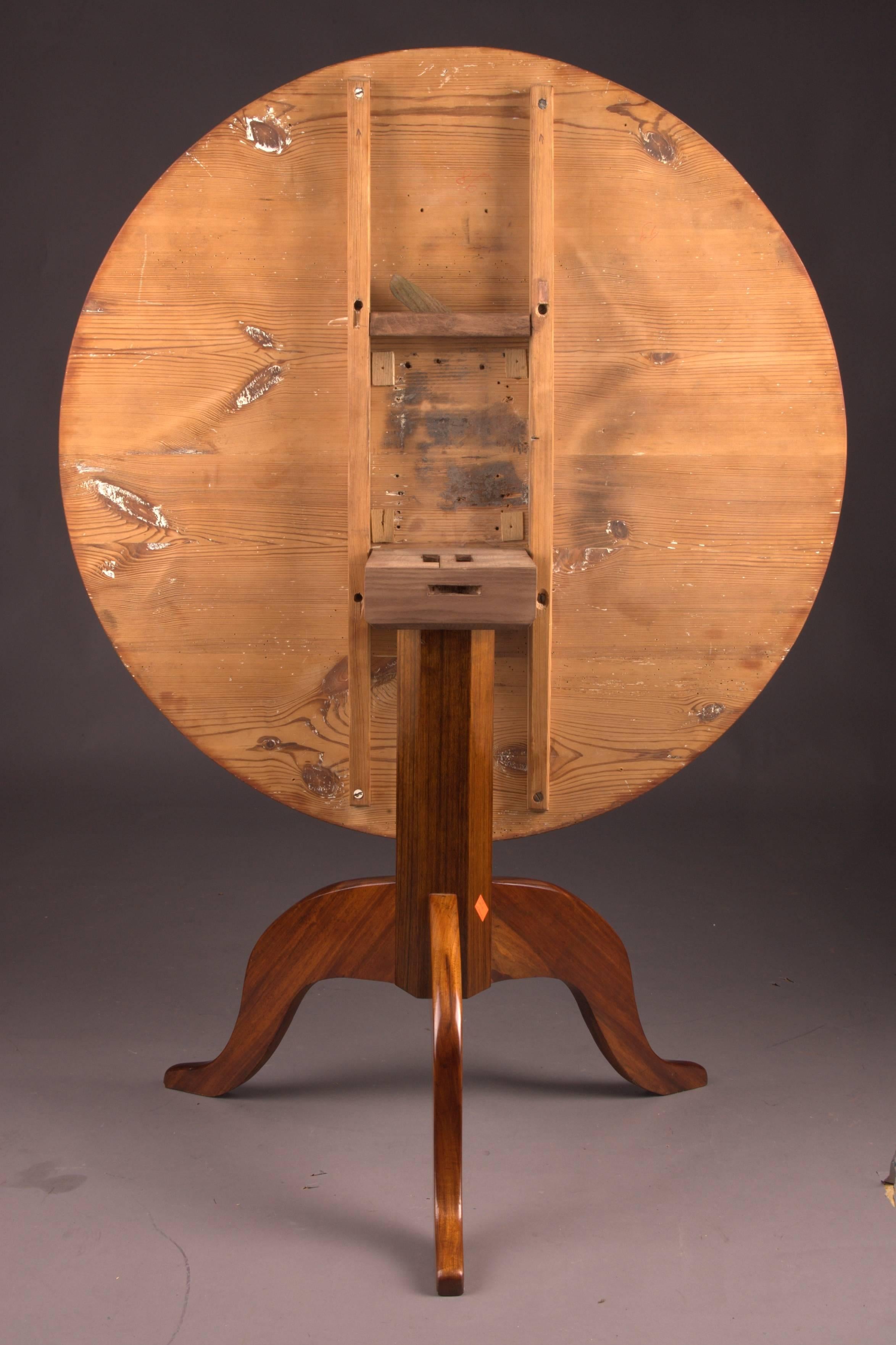 Acajou sur bois massif. Arbre de colonne octuple. En dessous, il y a trois pieds courbés en forme de volute. Joues droites pour une table ronde. Une forme stricte du temps du début du Biedermeier. Il est équipé d'un mécanisme de pliage.
Cette table