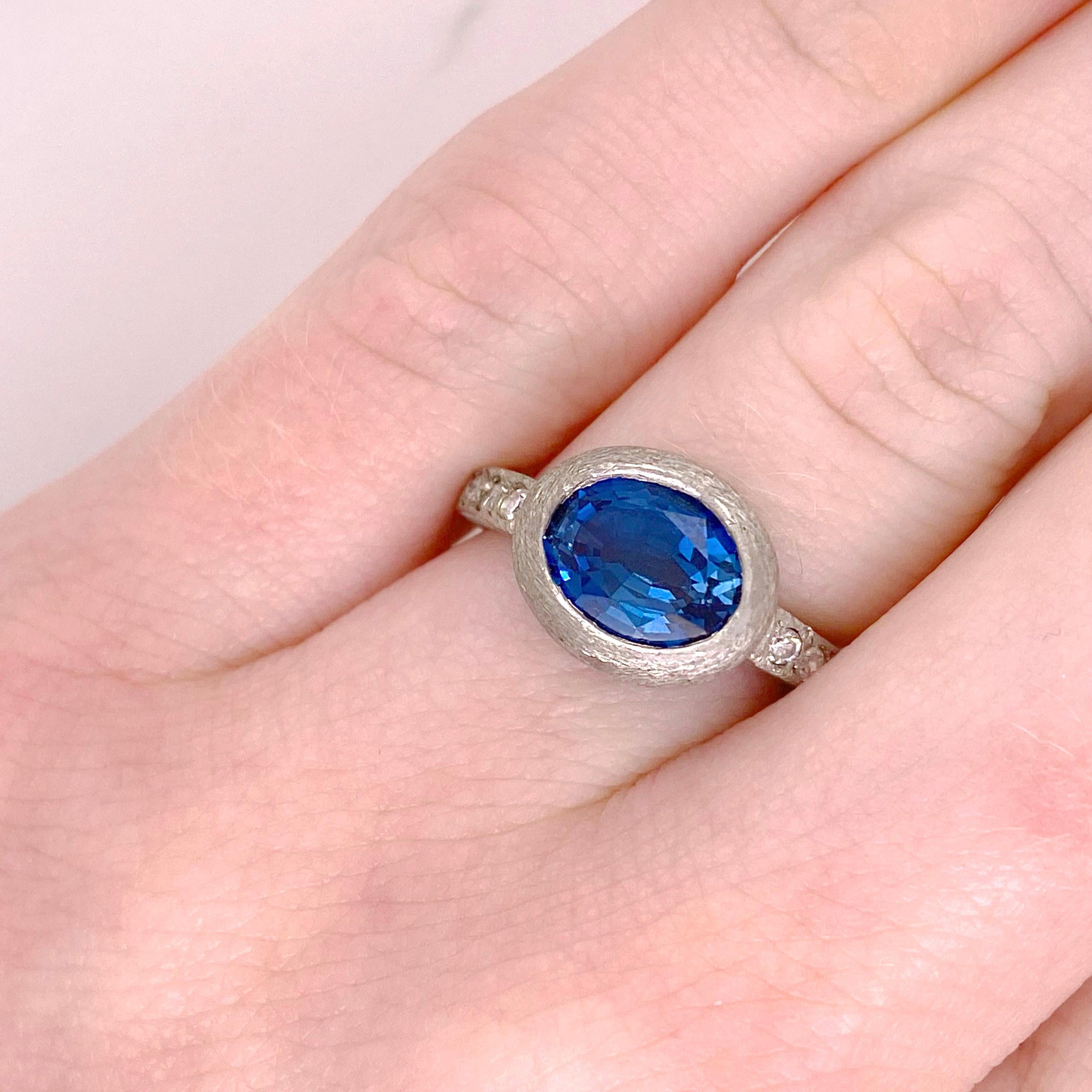 Notice the originality of this one-of-a-kind ring. The bezel and band are all hand fabricated from 14 karat white gold. The bezel was created to fit the 3.17 carats royal blue topaz (the most desirable color). The rock finish was created to enhance