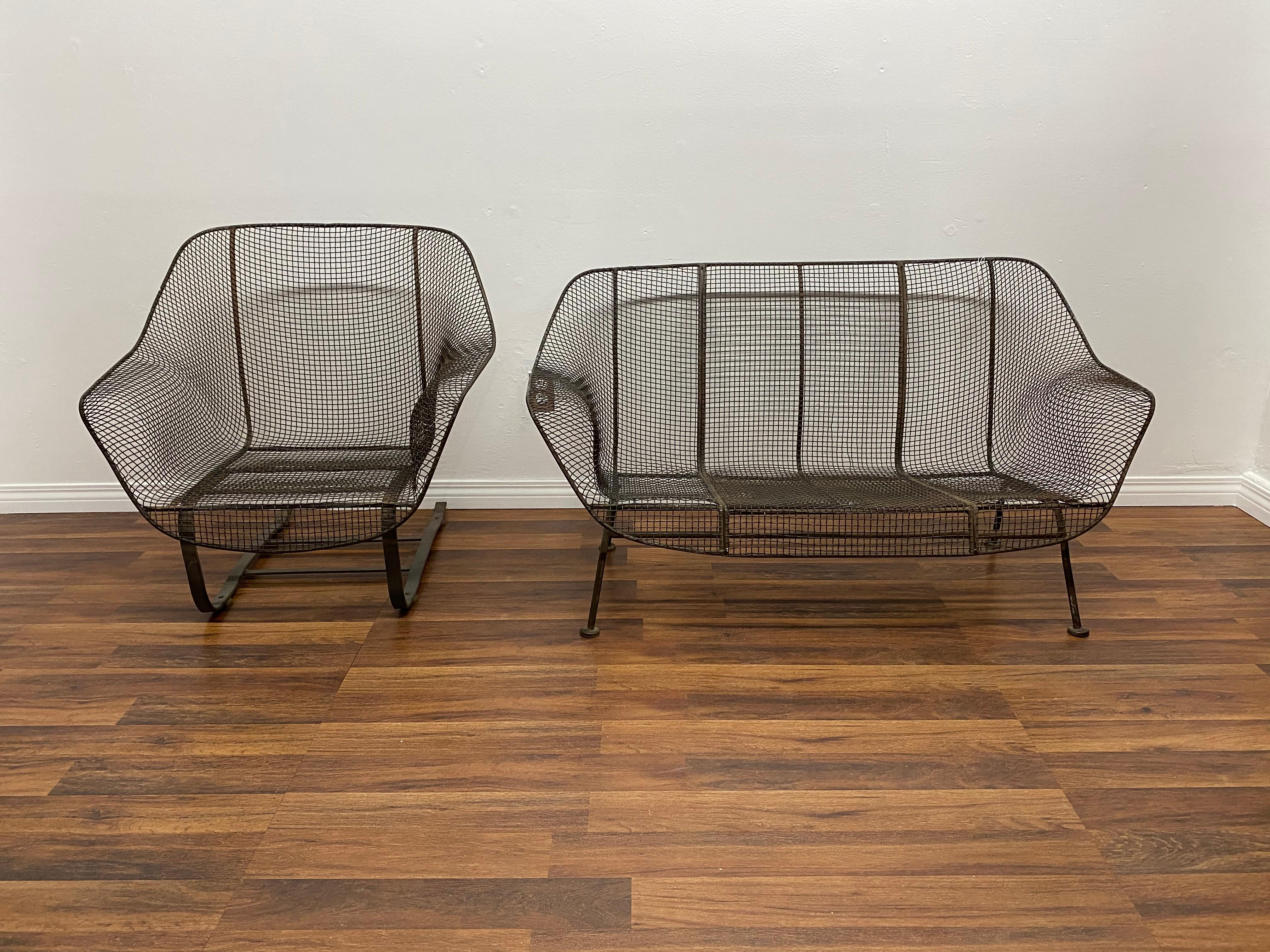 A 1950s wrought iron and steel mesh settee and cantilevered rocking chair from Russell Woodard's Classic and iconic Sculptura line. Original finish, age appropriate wear no broken welds or mesh

Measures: Settee H 27 in. x W 52.5 in. x D 28