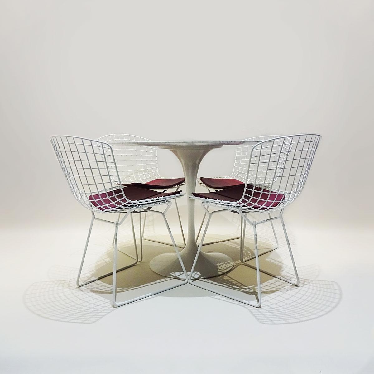 A classic mid century dining set comprising an original white marble Eero Saarinen round tulip dining table matched to 4 x white Harry Bertoia wire chairs with original seat pads.

This is a classic combination of complimentary designs that both