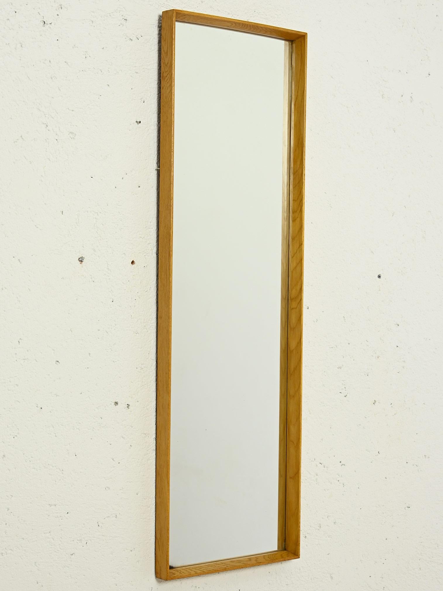 Original 1960s vintage Scandinavian mirror.

A clean, linear Nordic design mirror made of oak wood.
The rectangular shape makes it ideal as a wall mirror, adapting to any room. The thin edges and slightly raised frame add a touch of sophistication,