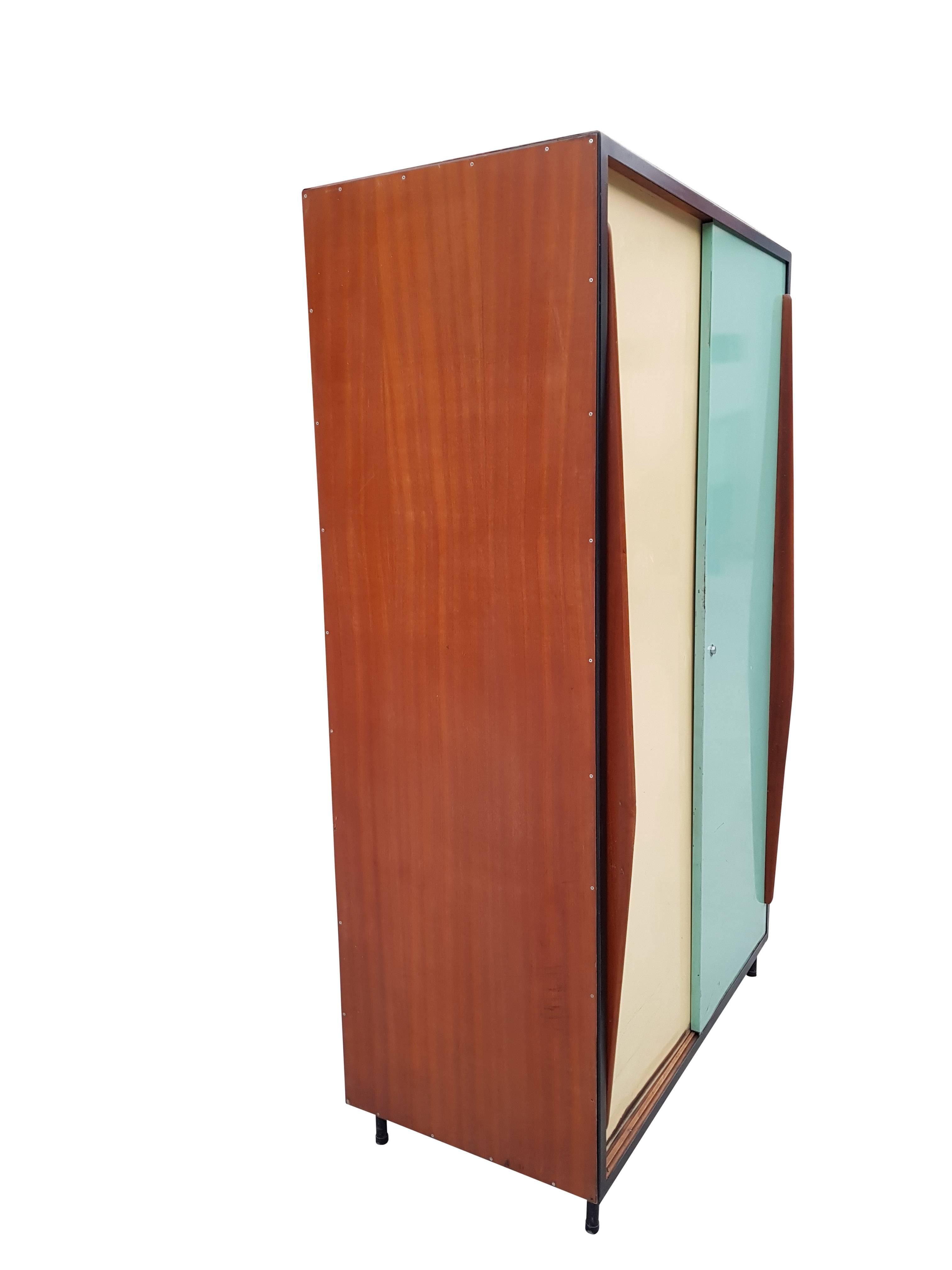 Original cabinet designed by the Belgium architect Willy Van Der Meeren for Tubax.
The cabinet has plywood sides. The back of the cabinet is provided with a black metal panel. On the front side there are two sliding doors in original colors with