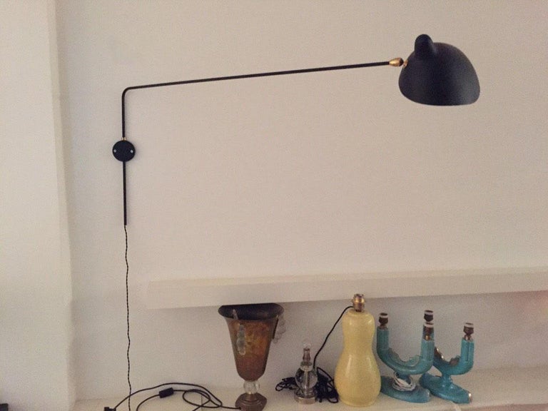 An original one-arm wall lamp, black metal, designed by Serge Mouille, France, in 1954. Matt black outside, sconce white semi mat inside. Measures: Vertical arm 51cm x Horizontal arm including scone 127cm. Sconce L 23cm x W 23cm x H 15cm.
The round