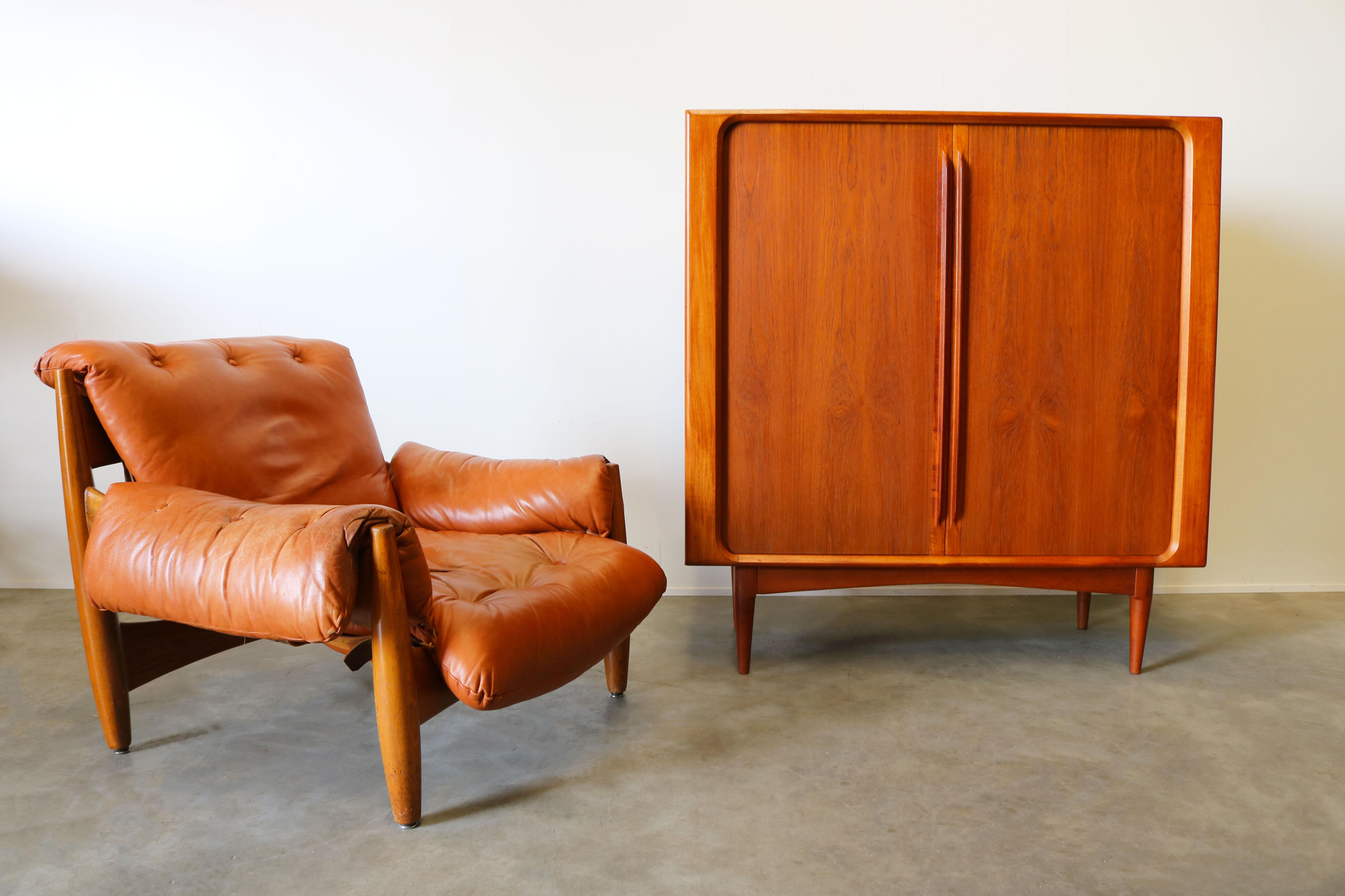 Rare and fully original ''Sheriff'' lounge chair designed by the father of Brazilian modern design Sergio Rodrigues and produced by Isa, Italy, 1962. The lounge chair is made from Brazilian wood and beautiful thick cognac leather with just the right