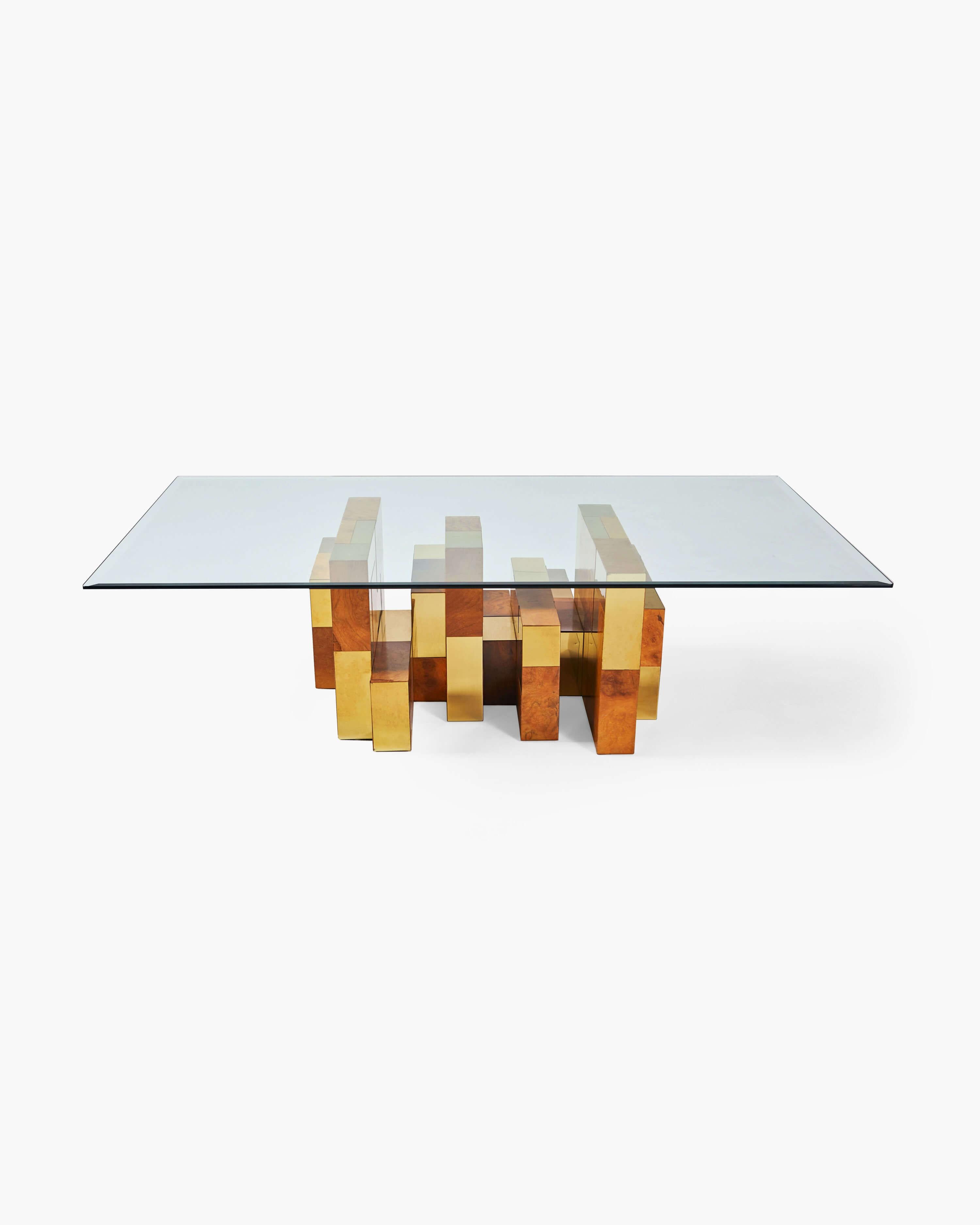 A sheet of tinted glass sits atop a base of burl-wood and brass intersecting polyominoes in this object of sculptural mastery. The piece highlights Evans' attunement to both form and function. As the name suggests, this interplay of reflective and