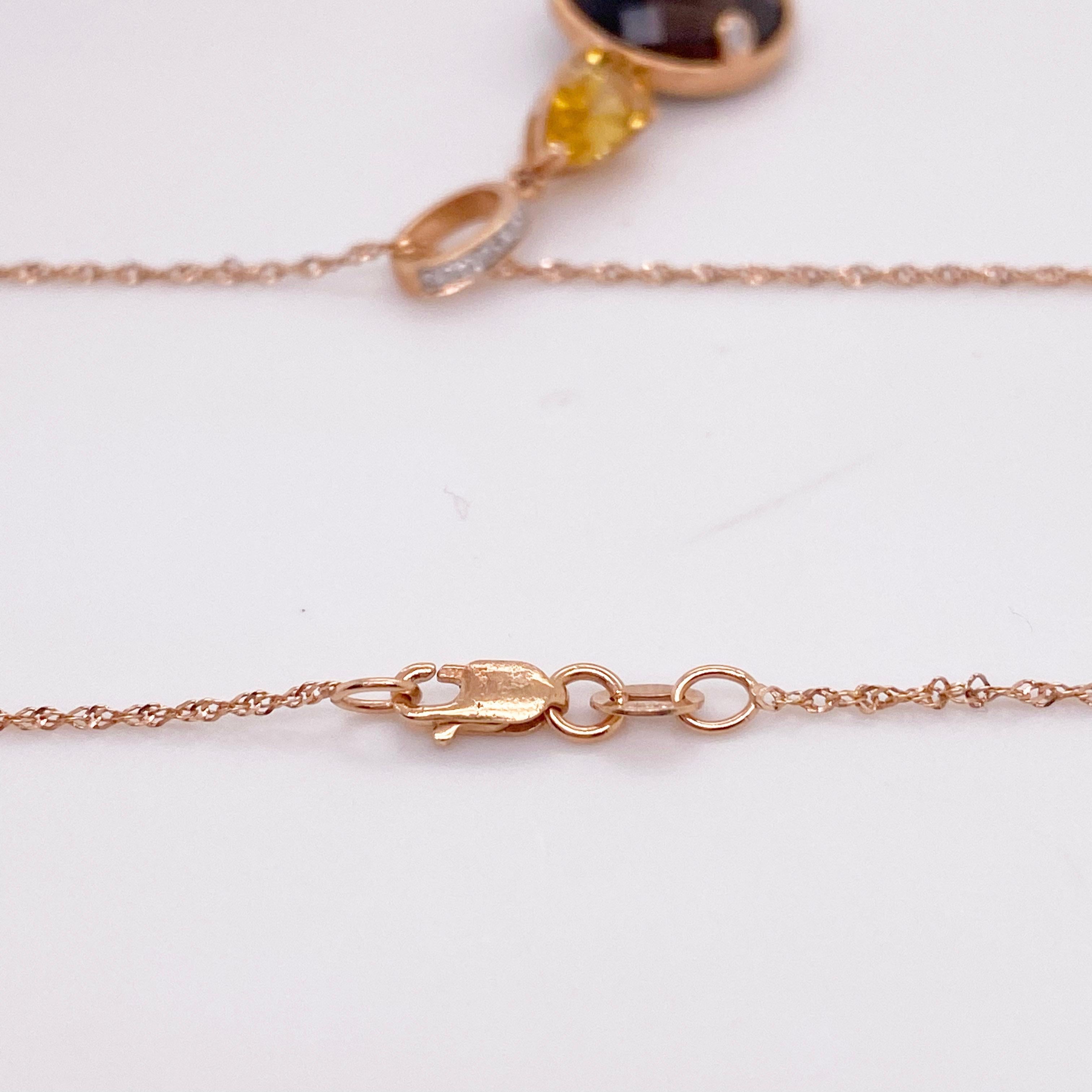 This artistic necklace has three parts: pave diamond bail, pear shaped golden citrine and rose cut smokey quartz. There are accent diamonds on the smokey quartz and the the gold work is all impeccable. The necklace makes a nice drop for a rounded or