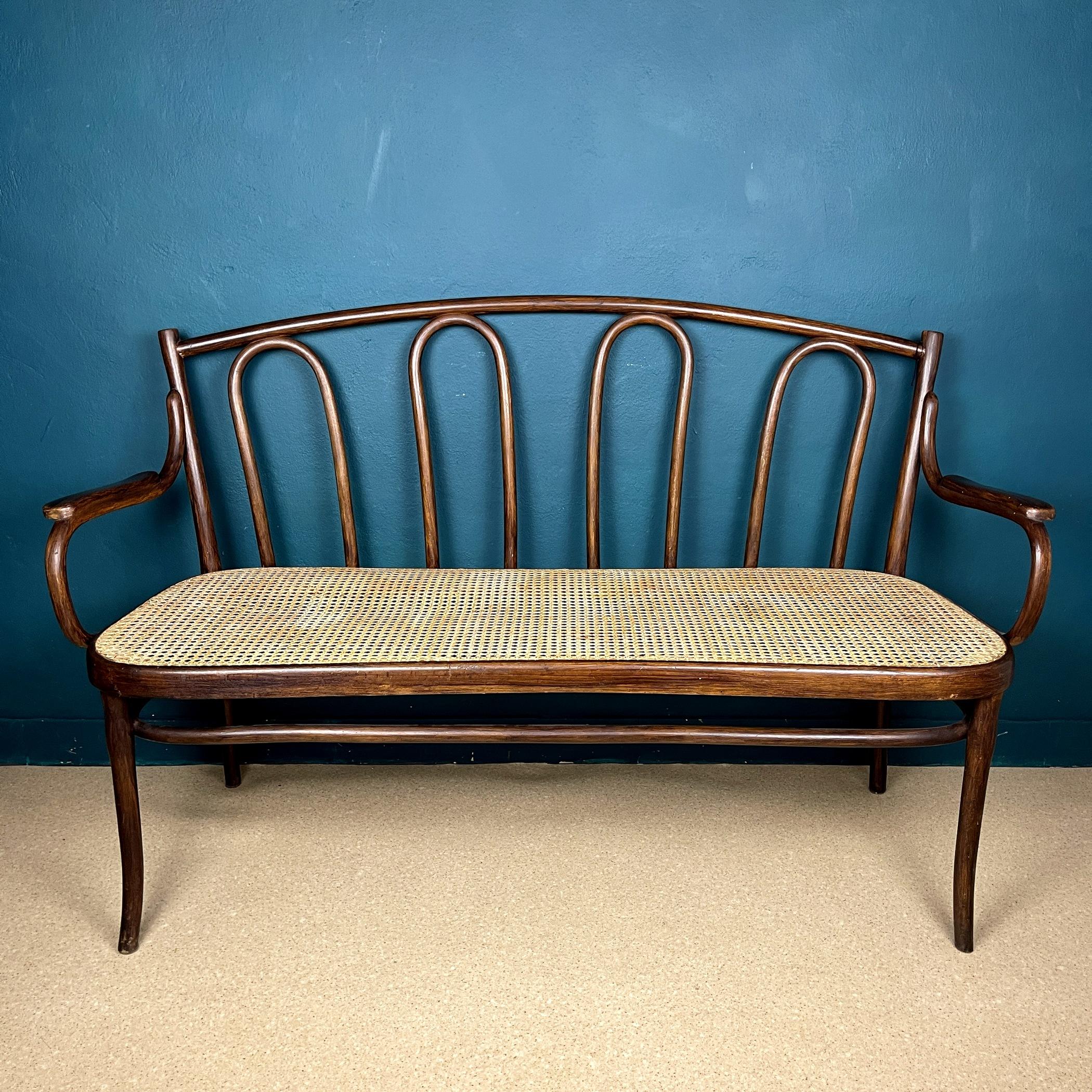 This beautifully preserved triple bench, crafted from steam-bent beech, originates from Austria and was manufactured by Gebrüder Thonet Vienna in the 1930s. It exudes the timeless charm of simple yet refined forms, showcasing the exceptional