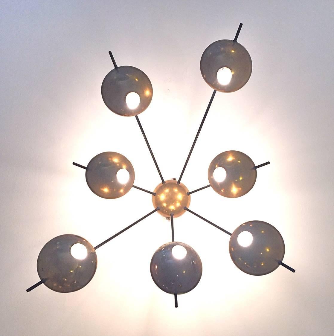An original vintage seven-shade wall or ceiling light, edited by Stilnovo in the 1950s. Polished brass and perforated shades and enameled metal arms. Rewired.
Porcelain bulb sockets and Stilnovo label.