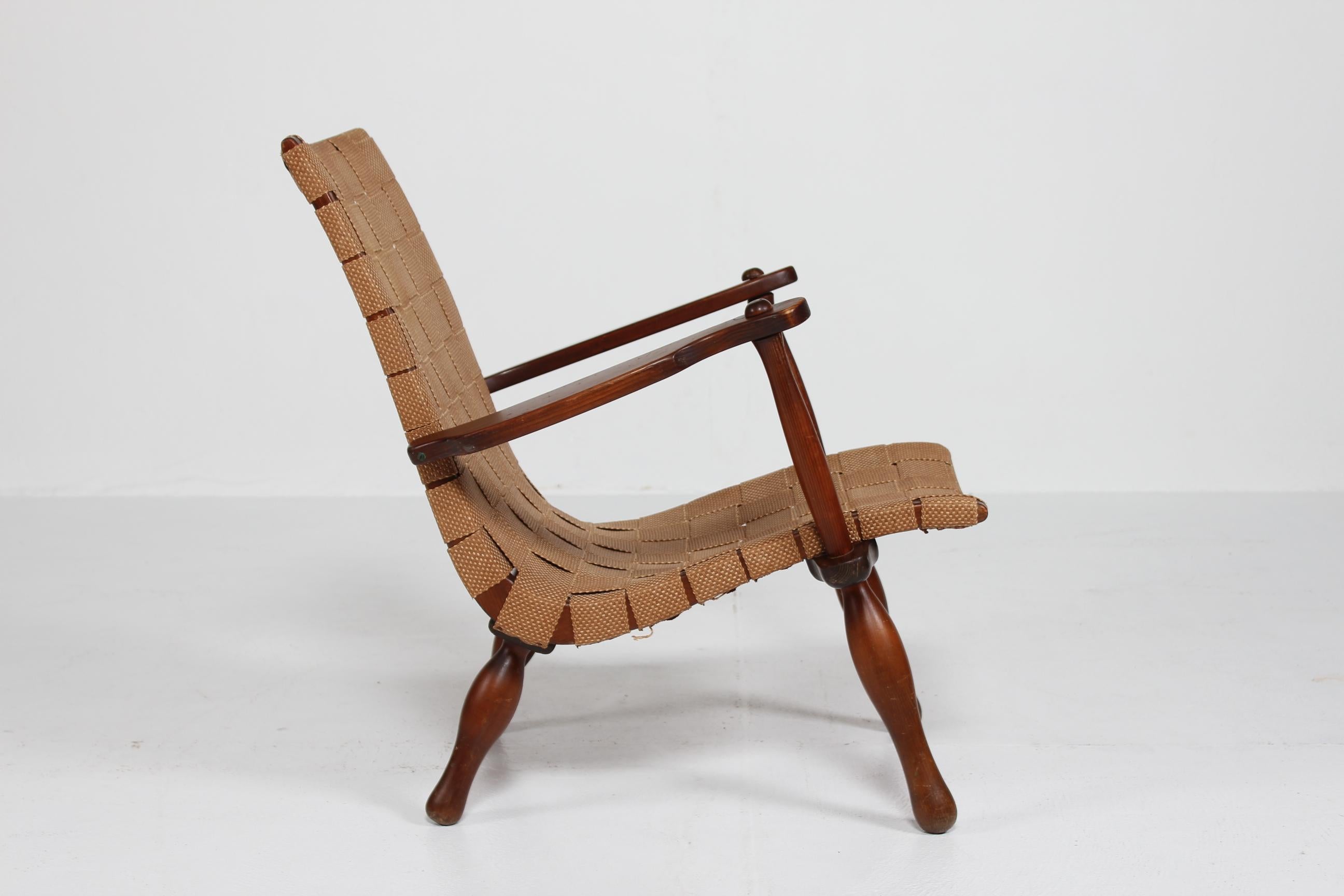 Butaca sueca vintage fabricada a mano en los años 30-1940 al estilo de Karl Schrøder, Erich Dieckmann, K. Scröder y Frits Schlegel.

Marco de madera maciza teñida de marrón, montado con una cinta ancha que lleva incrustado un hilo de color de