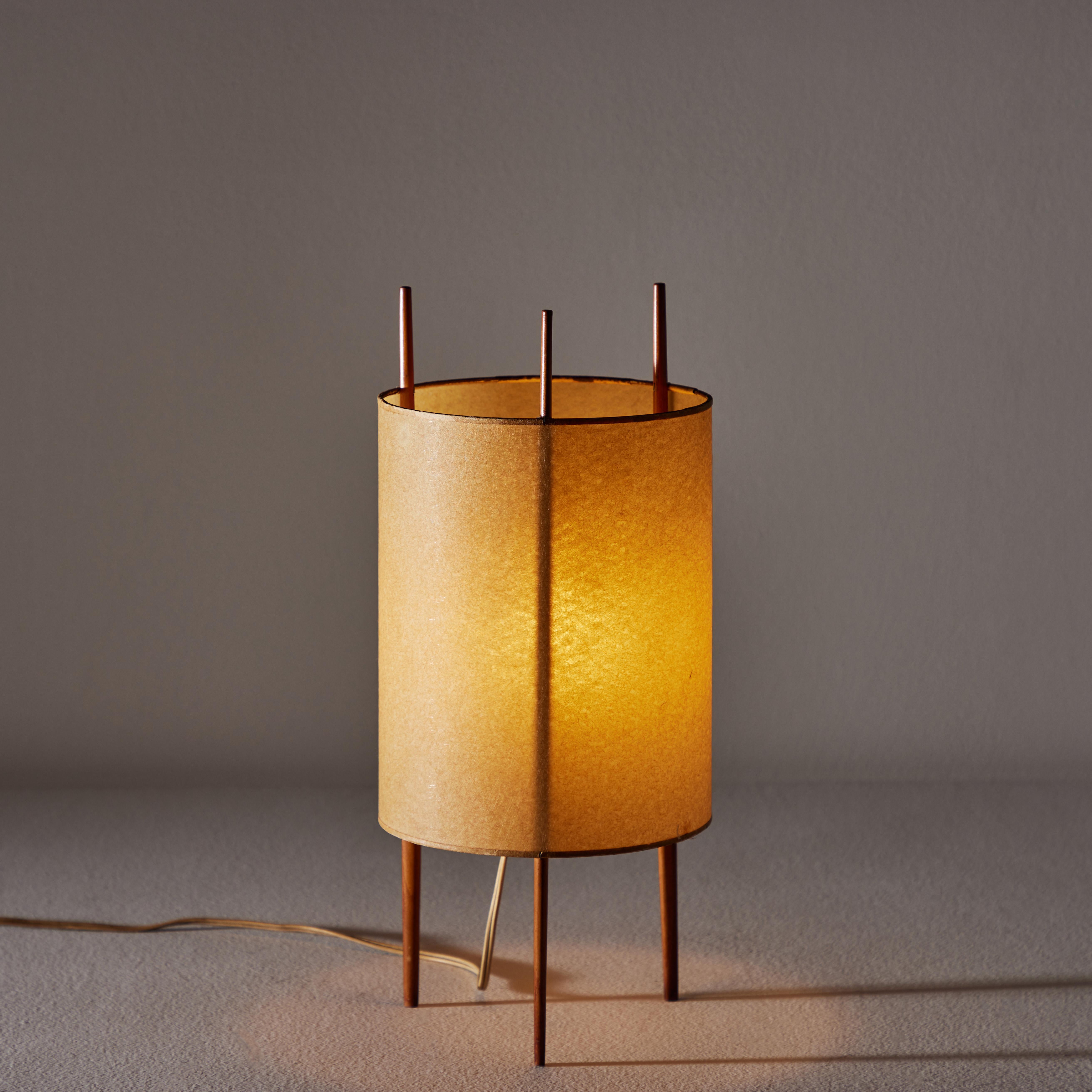 Rare and original table lamp by Isamu Noguchi for Knoll. Designed and manufactured by Knoll in the US circa the 1940s. Natural parchment shade is gently hoisted by three cherry wood pillars. Holds one E14 socket and bulb recommendation consists of
