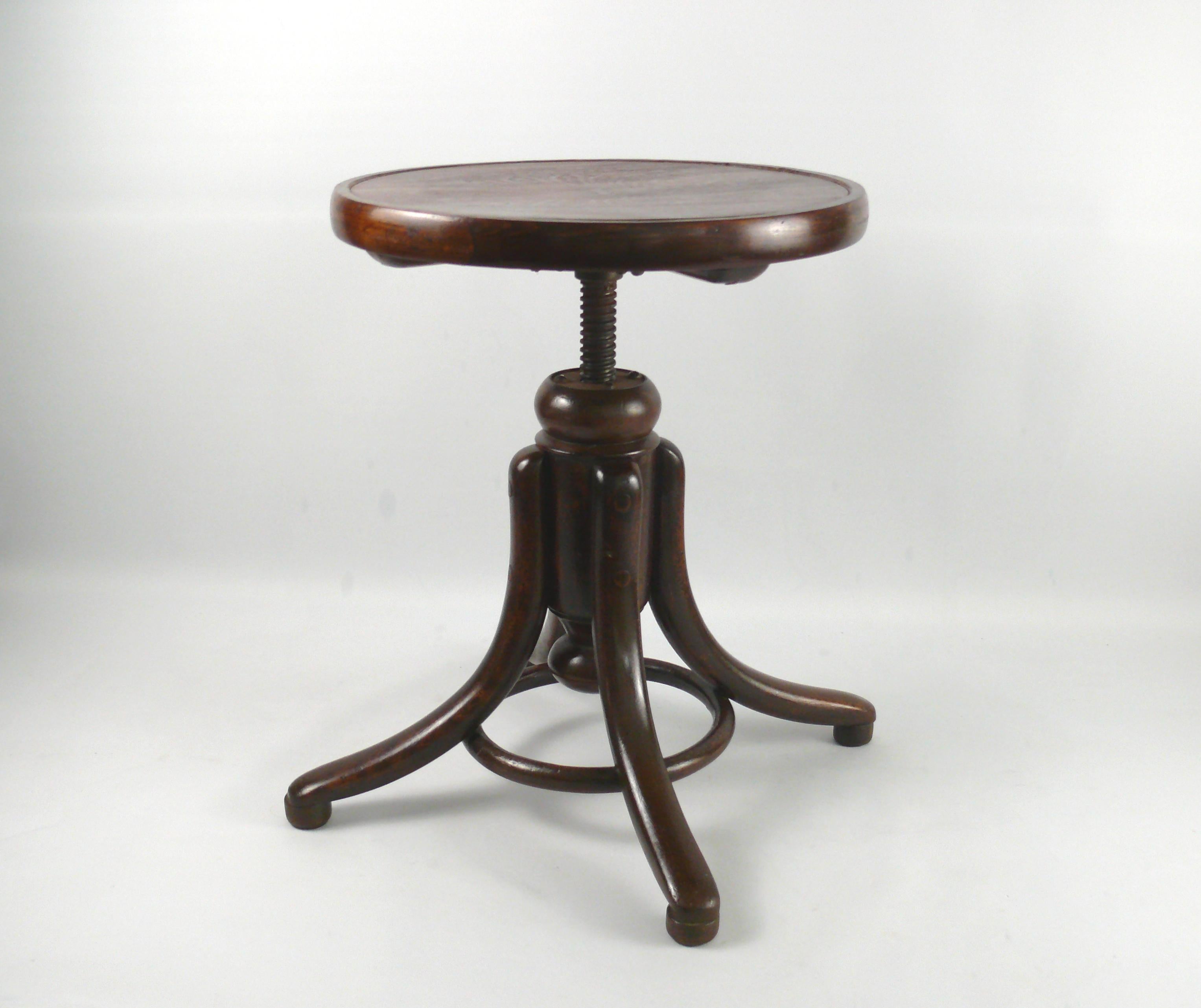 Original bentwood piano stool/swivel stool from Gebrüder Thonet. The piano stool is made of dark-stained (rosewood) beech wood painted with shellac and has four steam-bent feet with bentwood rings for stability. The stool can be adjusted in height