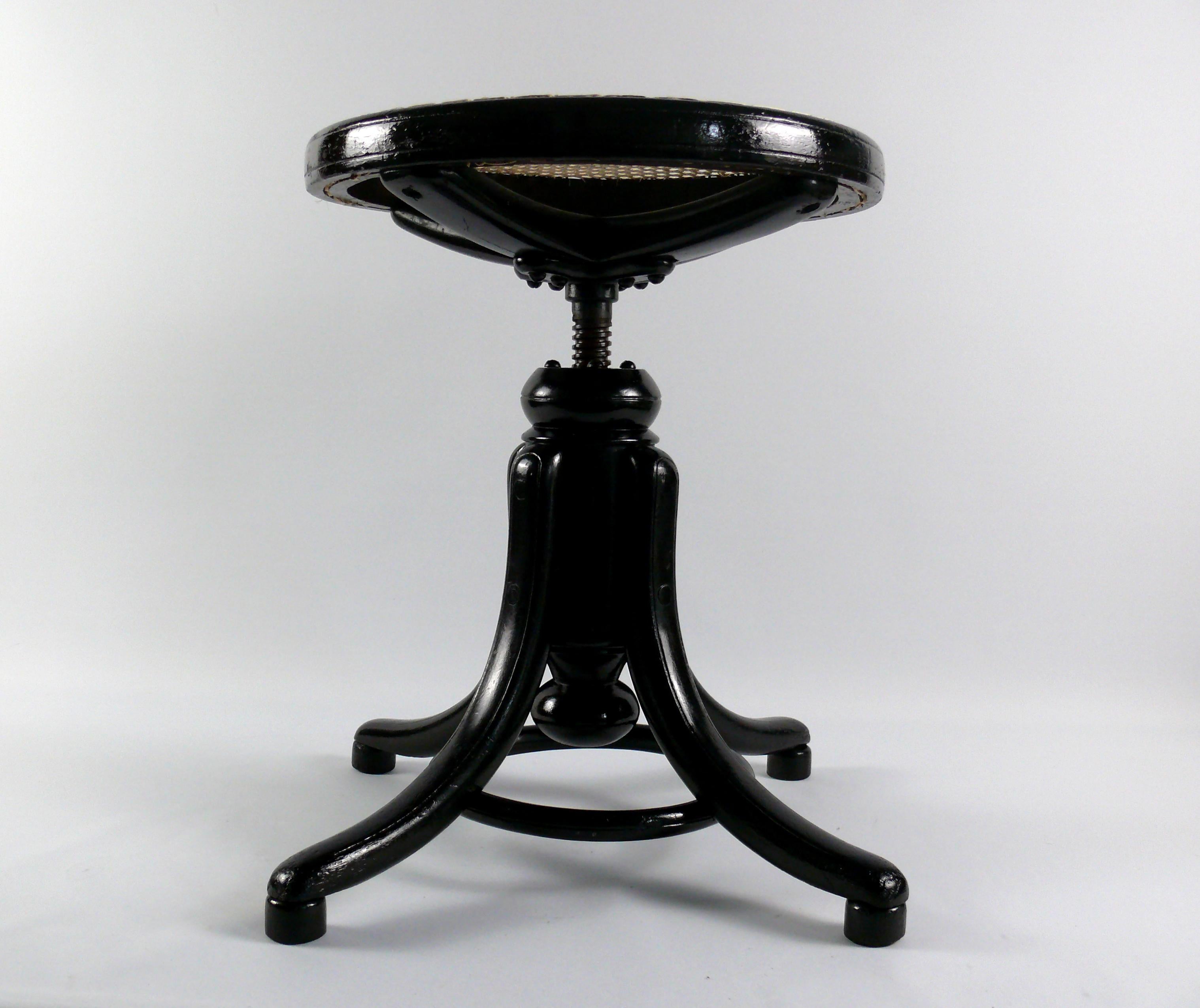 Swivel stool No.1 from the traditional company Gebrüder Thonet, Vienna from the late 19th century. The piano stool is made of black lacquered wood and has a frame with a bentwood ring. The curved feet are held together by the wooden ring made of