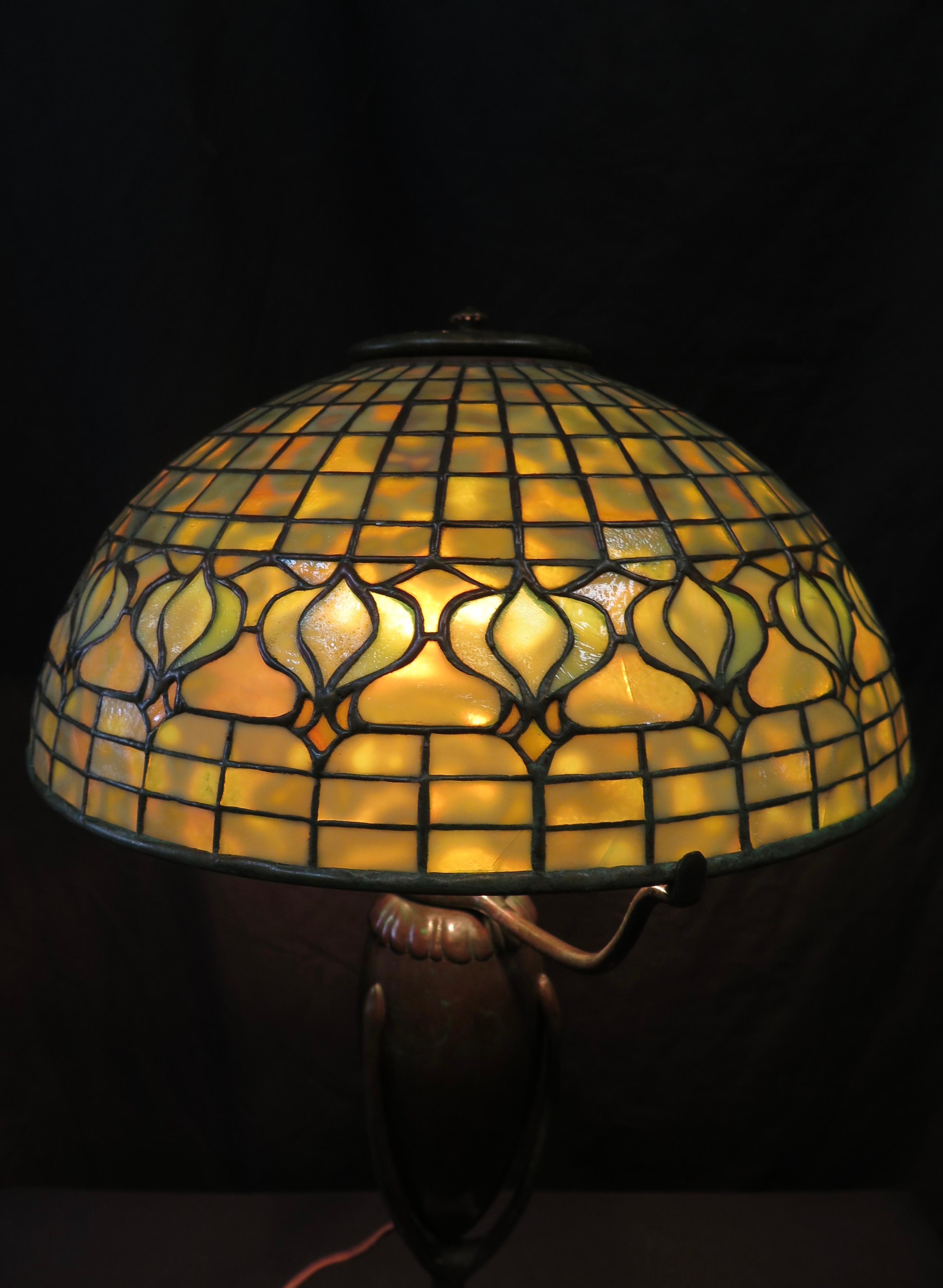 This vintage early 20th century leaded glass and bronze table lamp was made by the Tiffany Studios, New York. The handcrafted leaded 14