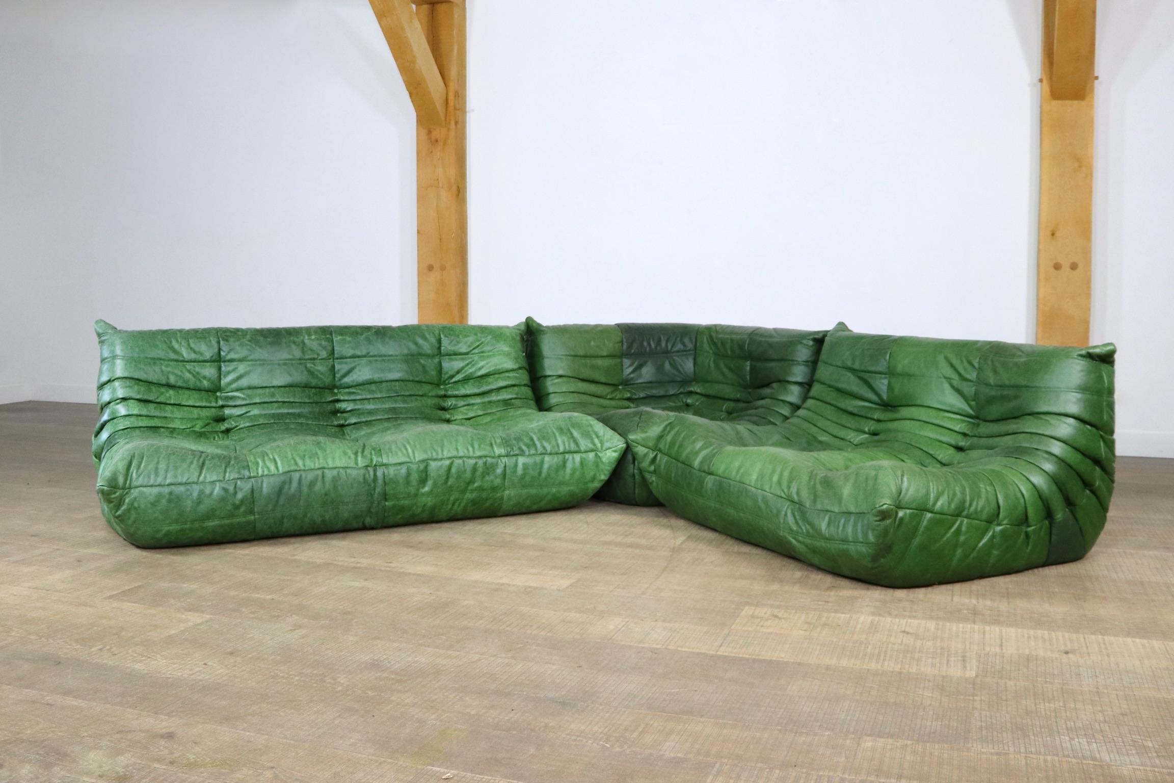 Beautiful original green leather Togo seating group by Michel Ducaroy for Ligne Roset, 1970s. The whole seating group still has the original vintage Ligne Roset logo. The set consists of a 2-seater, a 3-seater and a corner element. This incredible