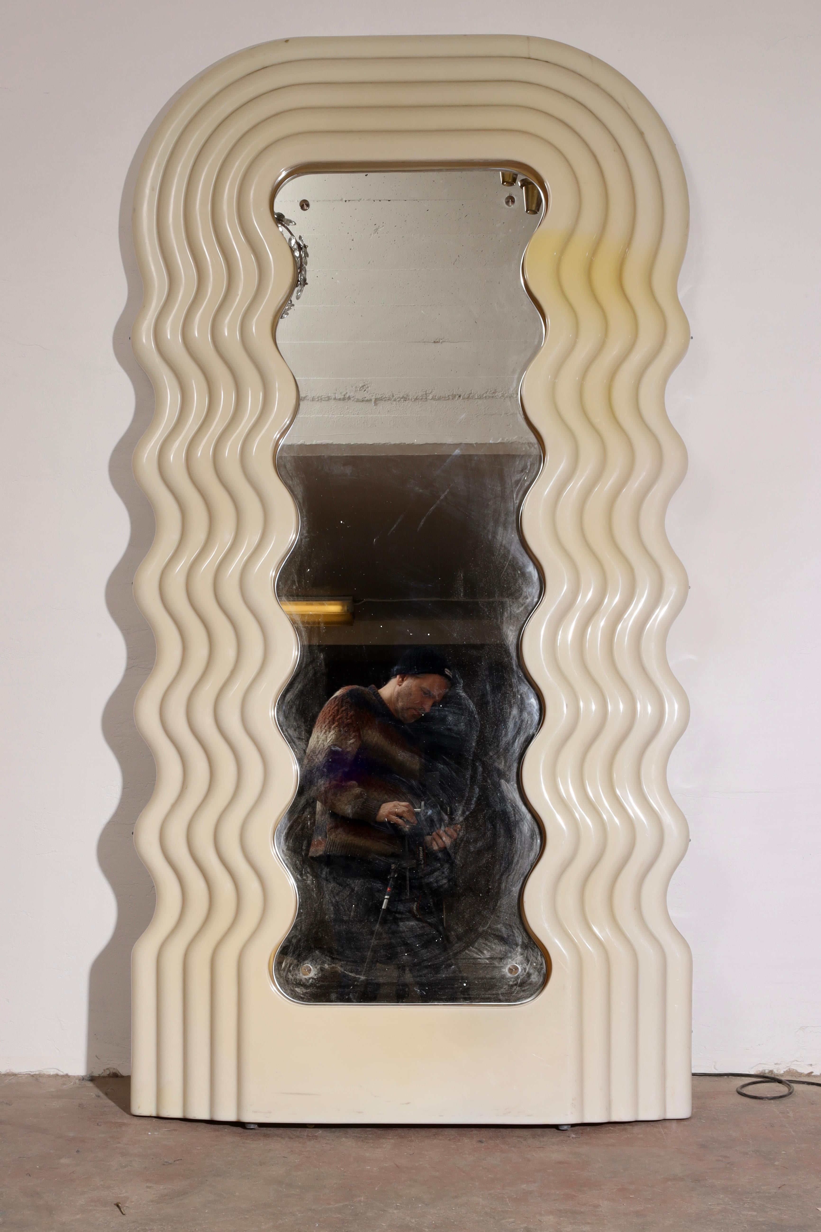 Modèle original de la première édition du miroir Ultrafragola conçu par Ettore Sottsass pour Poltronova. Miroir lumineux avec coque en acrylique faite de vagues superposées autour du miroir central qui imite le même design ondulé. Modèle original de