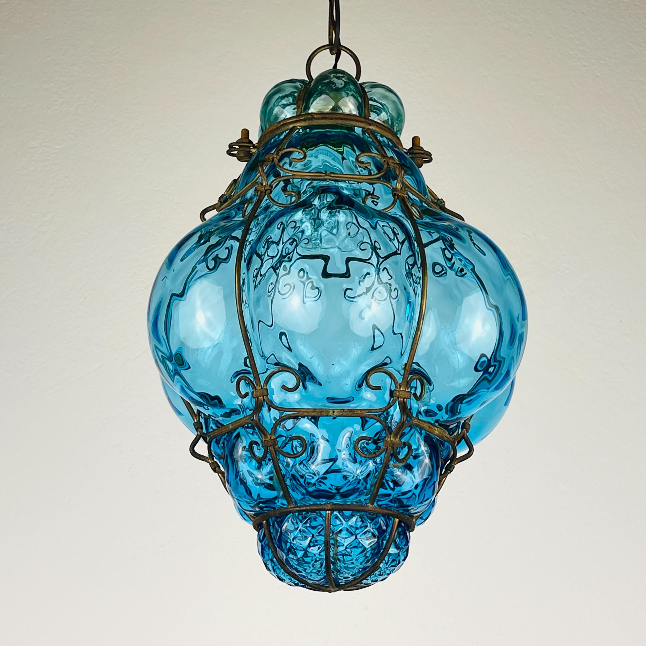 Original Blue Murano glass Venetian lantern made in Italy in the 1950s. The glass is blown within a metal frame that characterizes the shapes.

Vintage pendant lamp is in very good vintage condition. The metal has a nature