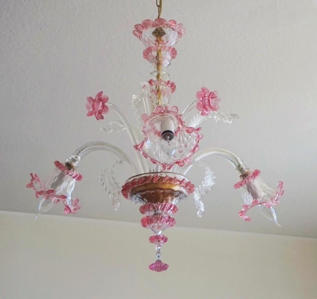 A lovely original Venetian handcrafted Murano three-arm chandelier, Italy, 1930-1939. Hand blown clear and vibrant pink glass decorated with flowers, up and down leaves and crown canopy. Three E14 candelabra light sockets.
Measures: Overall height