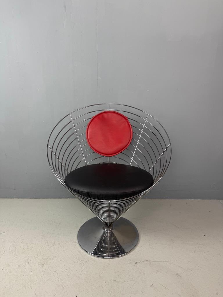 Bellissima icona di design, disegnata dal leggendario Verner Panton. Questa versione è molto rara, questa sedia in filo di ferro a cono ha una seduta molto comoda. I colori del tessuto Skai sono originali. Il cuscino della seduta è stato tappezzato
