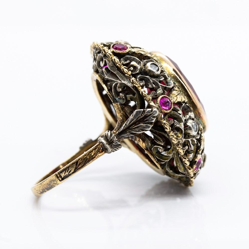 One oval cut synthetic ruby that weighs 8ctw constitutes the central stone of this unique ring.
Crafted in 18K Gold and silver, this amazing piece of jewelry displays 6 rose cut diamonds of I-SI1 quality that weigh 0.20ctw.
This lovely item of