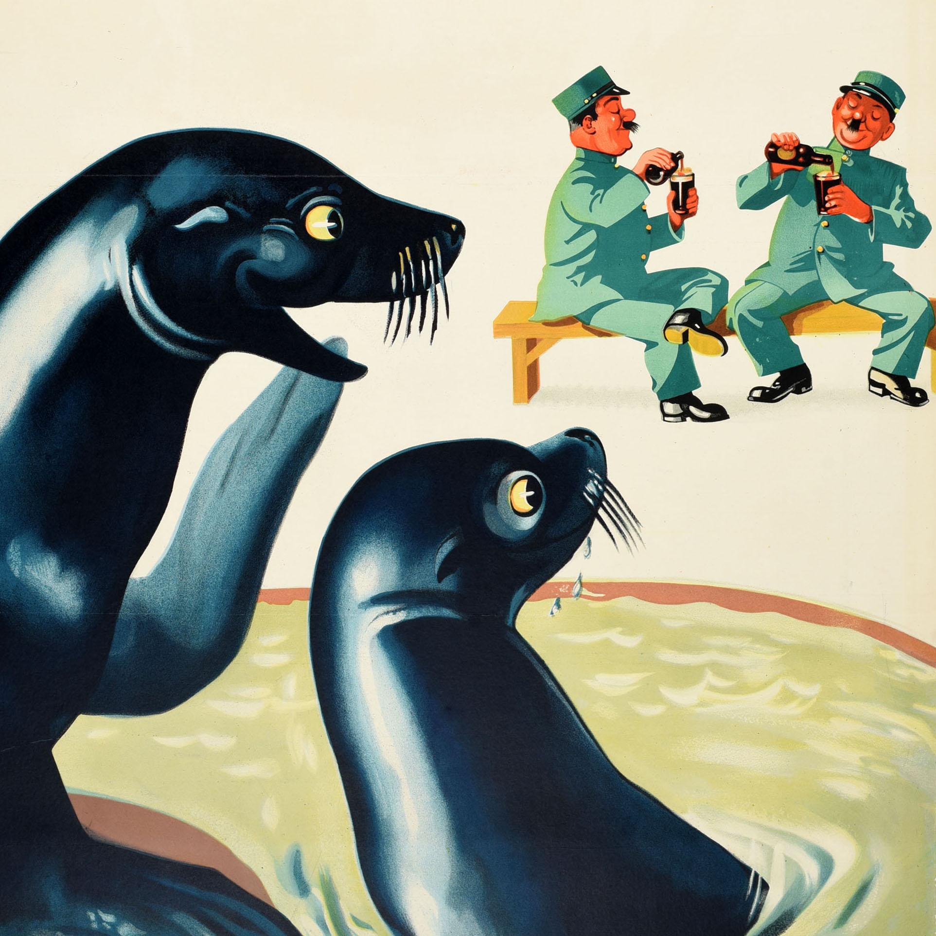 Original vintage advertising poster for the iconic drink Guinness Irish stout beer with the quote in red - Lovely Day For A Guinness - above a fun image of smiling seals looking at two zoo keepers sitting on a bench and pouring their bottles of