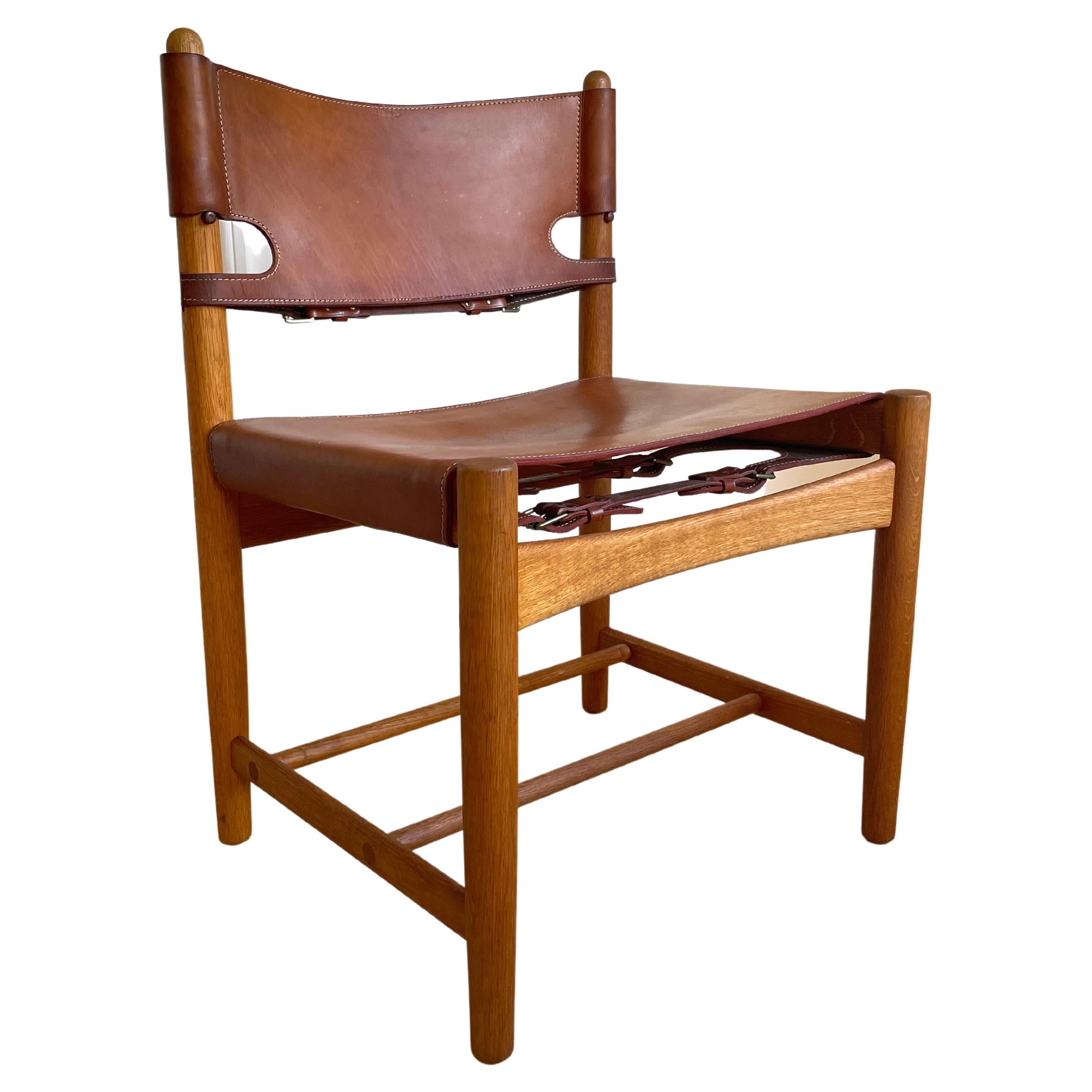 Original midcentury design icon. The Spanish dining chair from the early production years in the mid 1960s. The Danish Børge Mogensen oak wood classic with thick cognac saddle leather carefully cared for over the years and in beautiful vintage