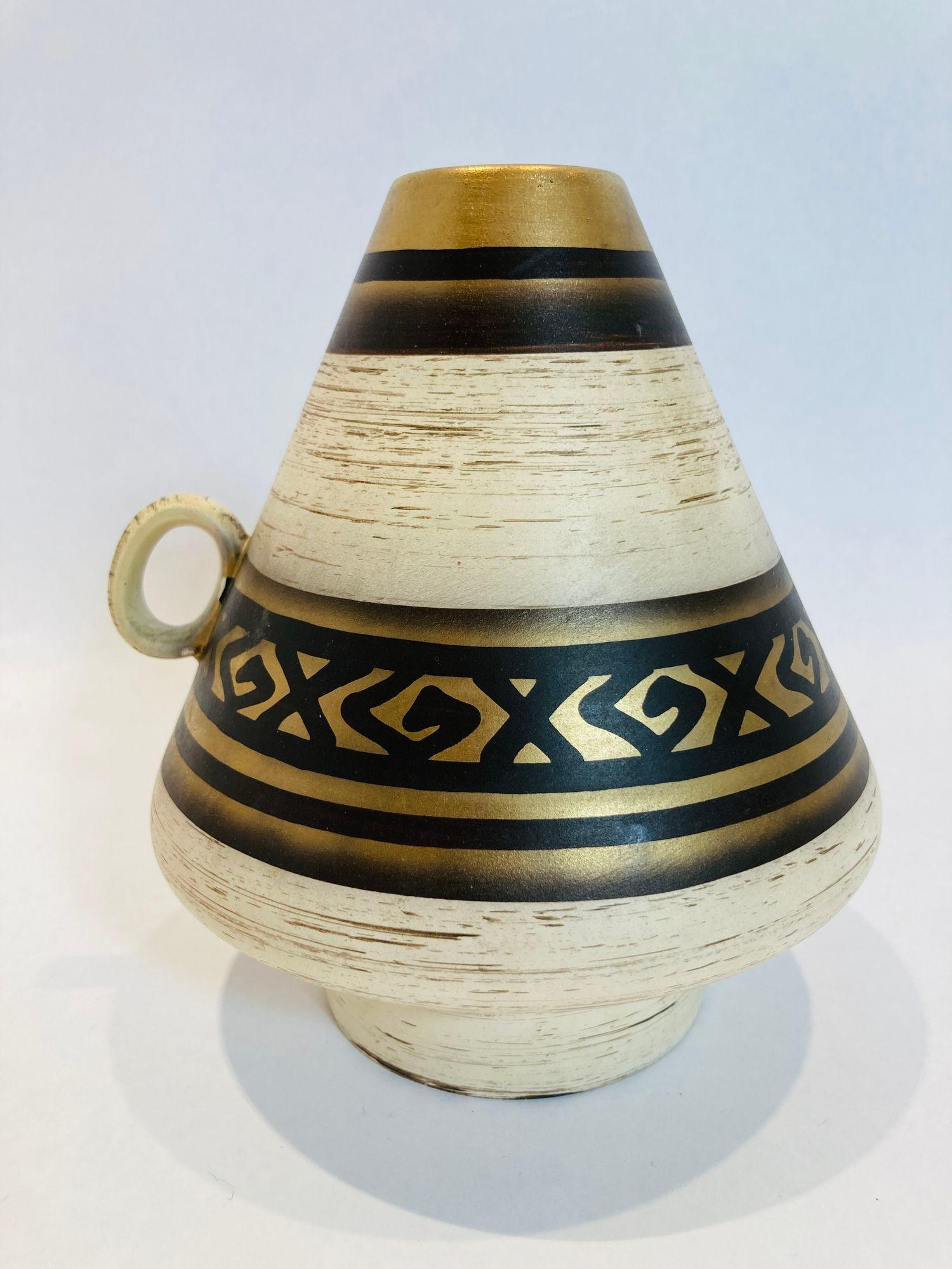 Vase vintage en céramique minimaliste fait à la main en Allemagne vers les années 1970.
Merveilleuse palette de couleurs neutres où prédomine le blanc cassé avec un motif géométrique doré.
Vase original en céramique des années 1970, fabriqué en