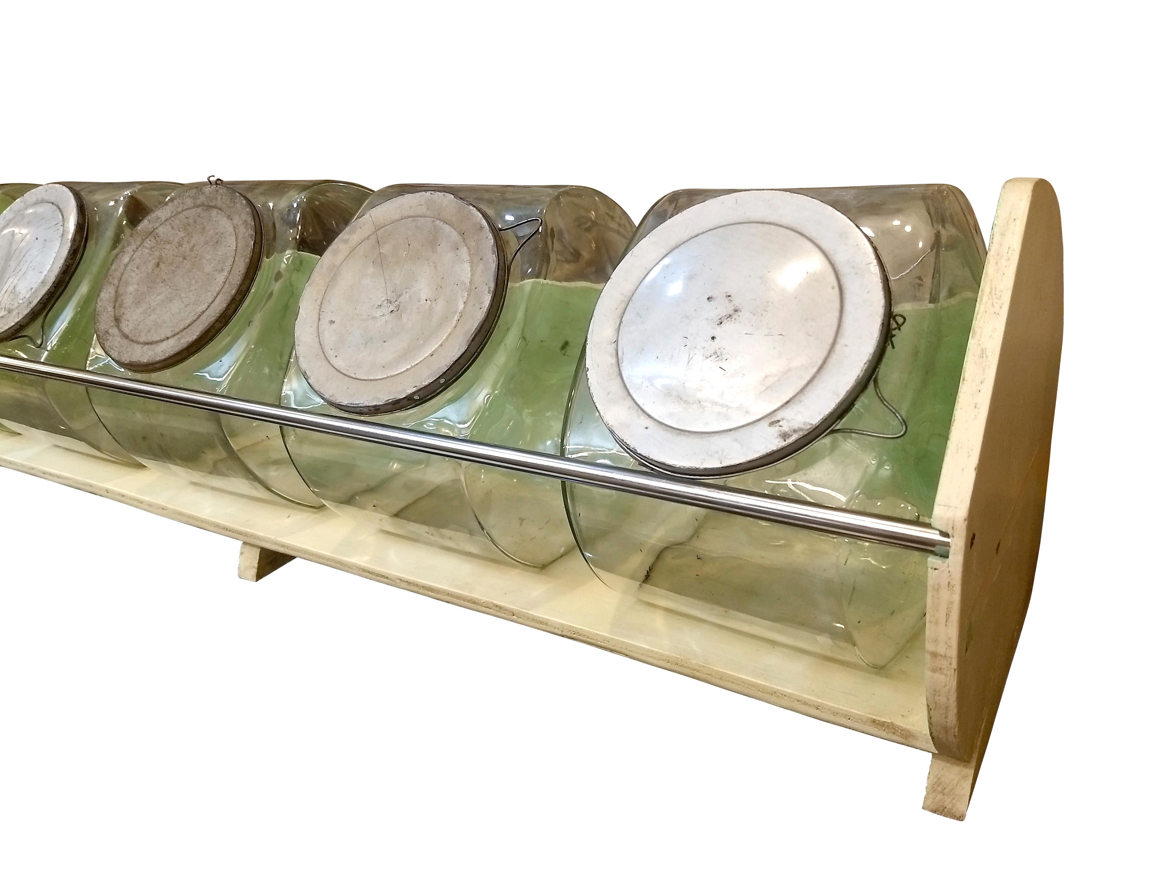 Original Display from a convenience neighborhood store in Mexico City probably from 1950. The display is made out of plywood painted in custard and pistachio colors with a protective chromed metal bar. It holds five original thick glass jars with